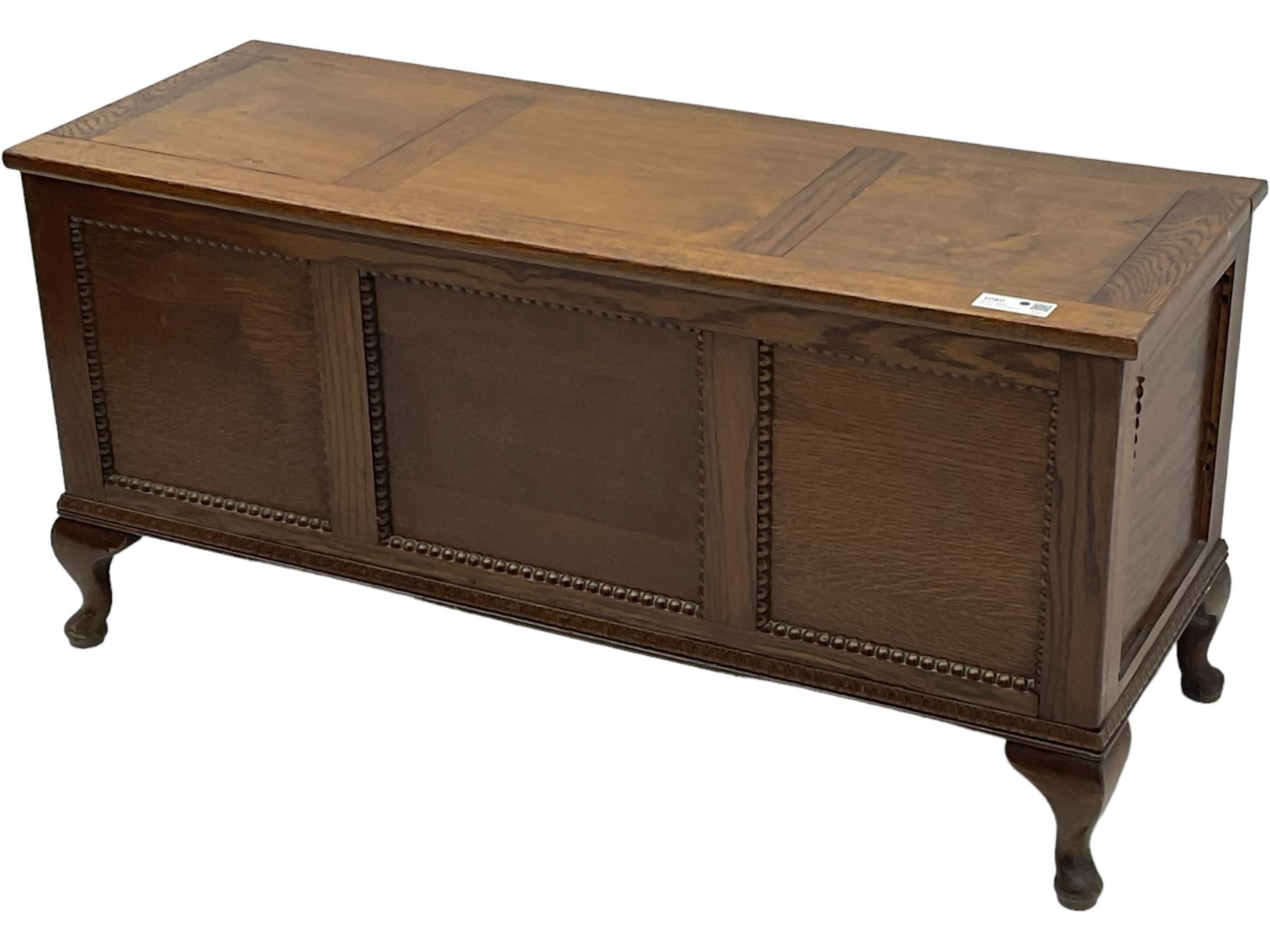 Early 20th century oak blanket chest, rectangular hinged lid with decorative panelling, the front and sides adorned with beaded panels, on cabriole feet