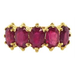 18ct gold five stone oval cut glass-filled ruby ring, with scroll design shoulders, London 2005