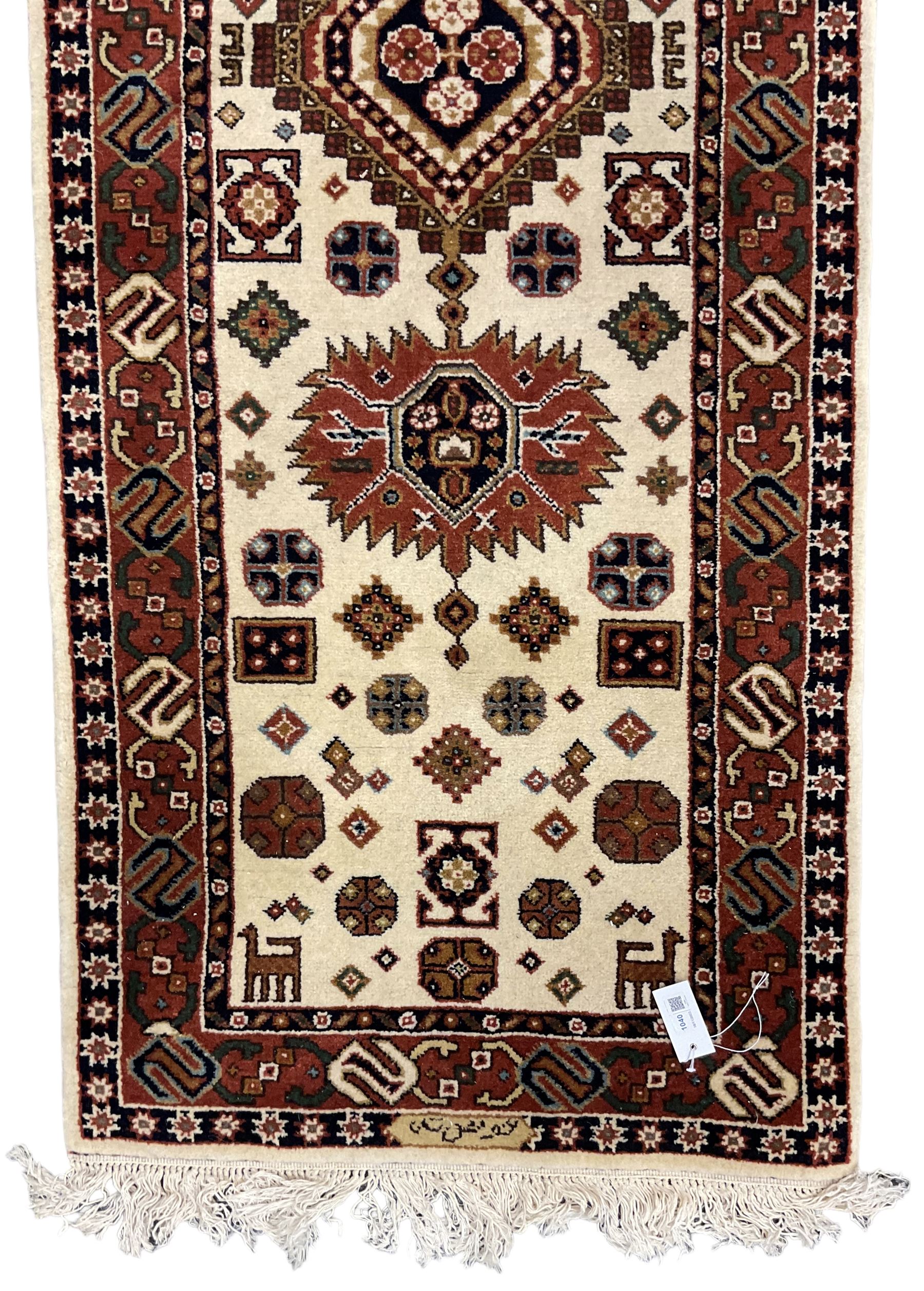 Persian design ivory ground rug, six lozenge medallions within a field of stylised animal and geometric motifs, the guarded border decorated with interconnected S motifs 