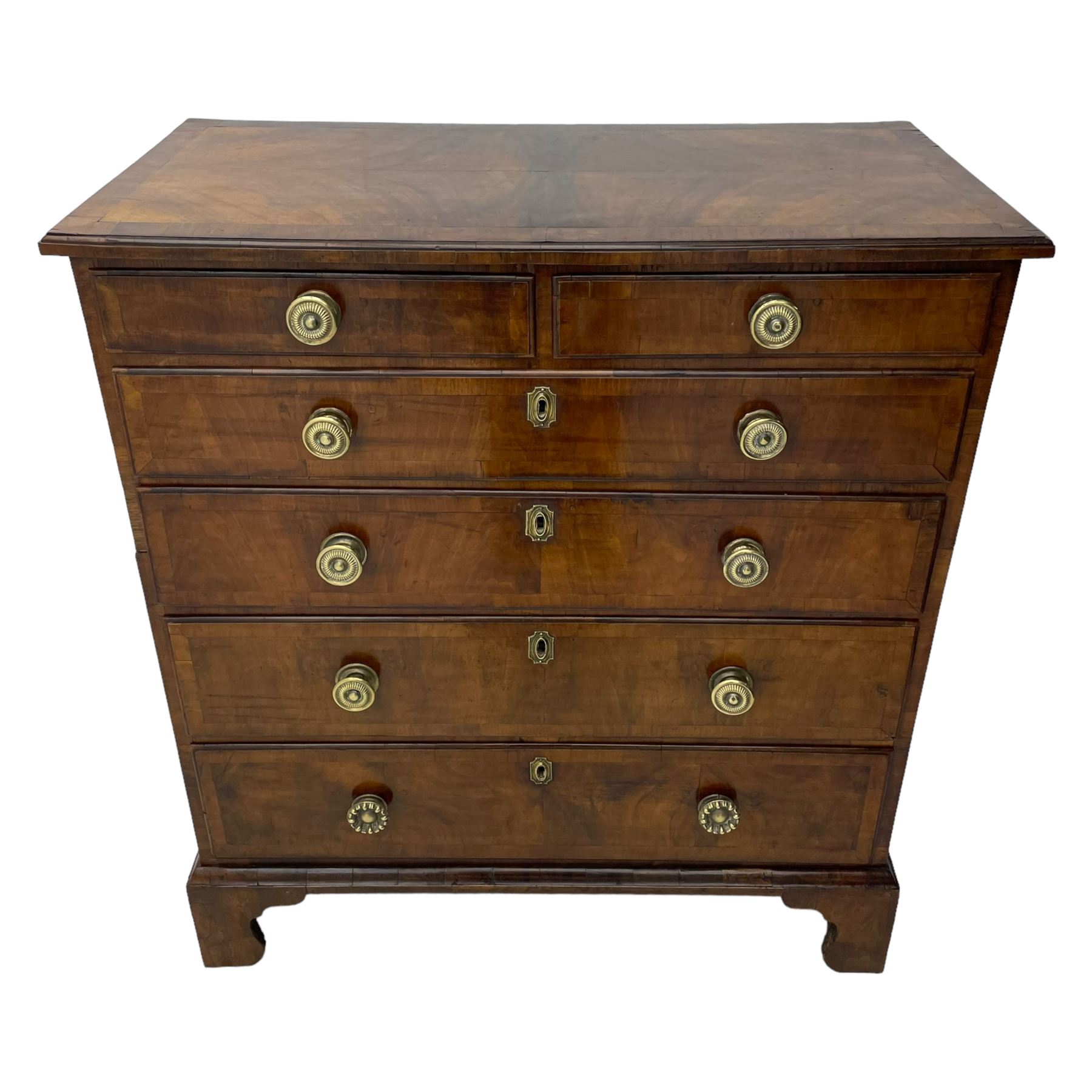 George I walnut chest, moulded rectangular top with book-matched veneers within crossbanding, fitted with two short over four long graduating drawers, moulded drawer fronts with brass handles, on bracket feet, the chest will split into two sections 