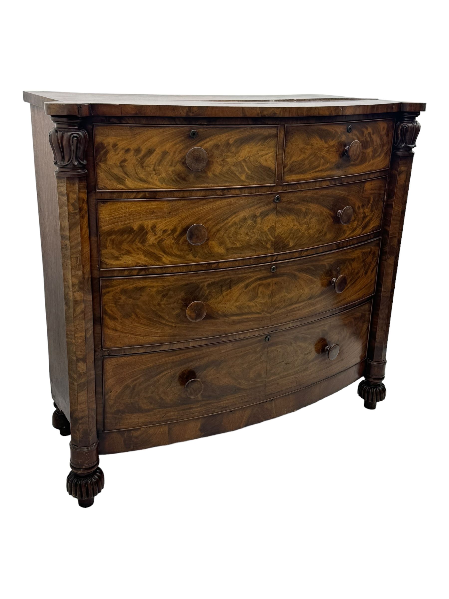 Early Victorian mahogany bow front chest, two short over three long graduating cockbeaded drawers, flanked by faceted columns with carved acanthus leaf capitals, standing on turned bun supports with fluted detailing