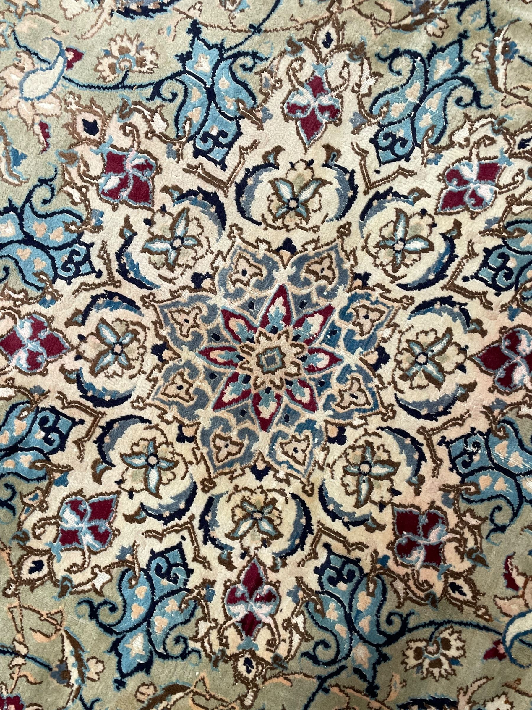 Persian Kashan olive ground carpet, central rosette medallion surrounded by swirling leafy branches and palmettes, the spandrels decorated with further palmettes and foliate motifs, scrolling border interspersed with stylised plant motifs, with in guard stripes