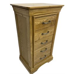 Contemporary light oak pedestal chest, moulded cornice and chamfered rectangular top with rounded fronts, over five drawers with metal handles and cock-beaded surrounds, on bracketed plinth base