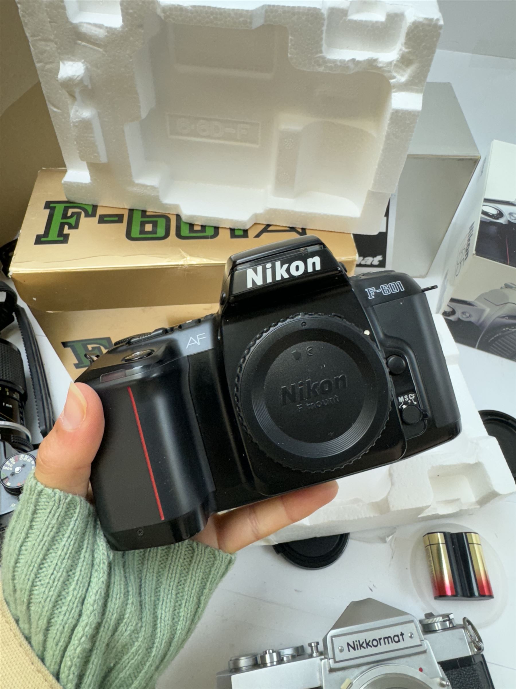 Collection of Nikon cameras, to include N65 serial no. 3103095, boxed, AF F-601 serial no. 2049522, boxed, F-801s serial no. 3330641, F-301 serial no. 3349050 and two Nikkormat cameras, to inlcude an EL example serial no. 5236494, with a nikkor Zoom 43-86mm 1:35 lens serial no. 913104, boxed and one other