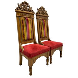 Set of six 20th century Carolean design oak high back chairs, the pediment carved with dragons and central Green Man mask with trailing foliage, the backs upholstered in striped fabric, on turned front supports