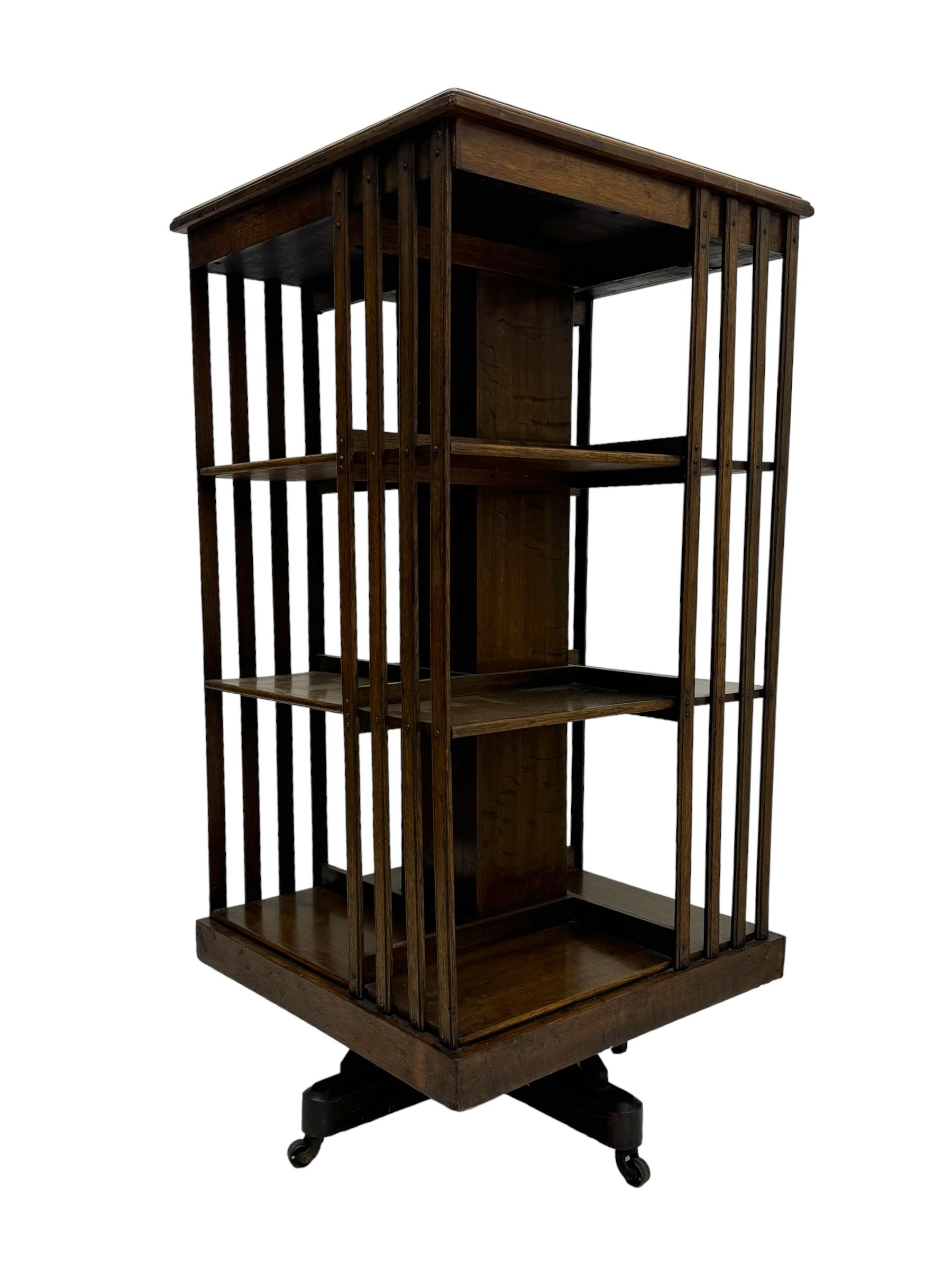 Early 20th century oak revolving bookcase, moulded square top over three tiers, with moulded vertical slats, on four spoke base with castors 