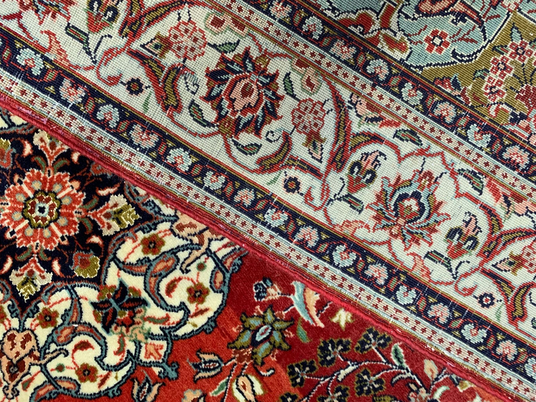 Small Persian Kashan crimson ground rug, the central interlaced medallion surrounded by scrolling foliate branches and stylised plant motifs, scrolling border with guard bands