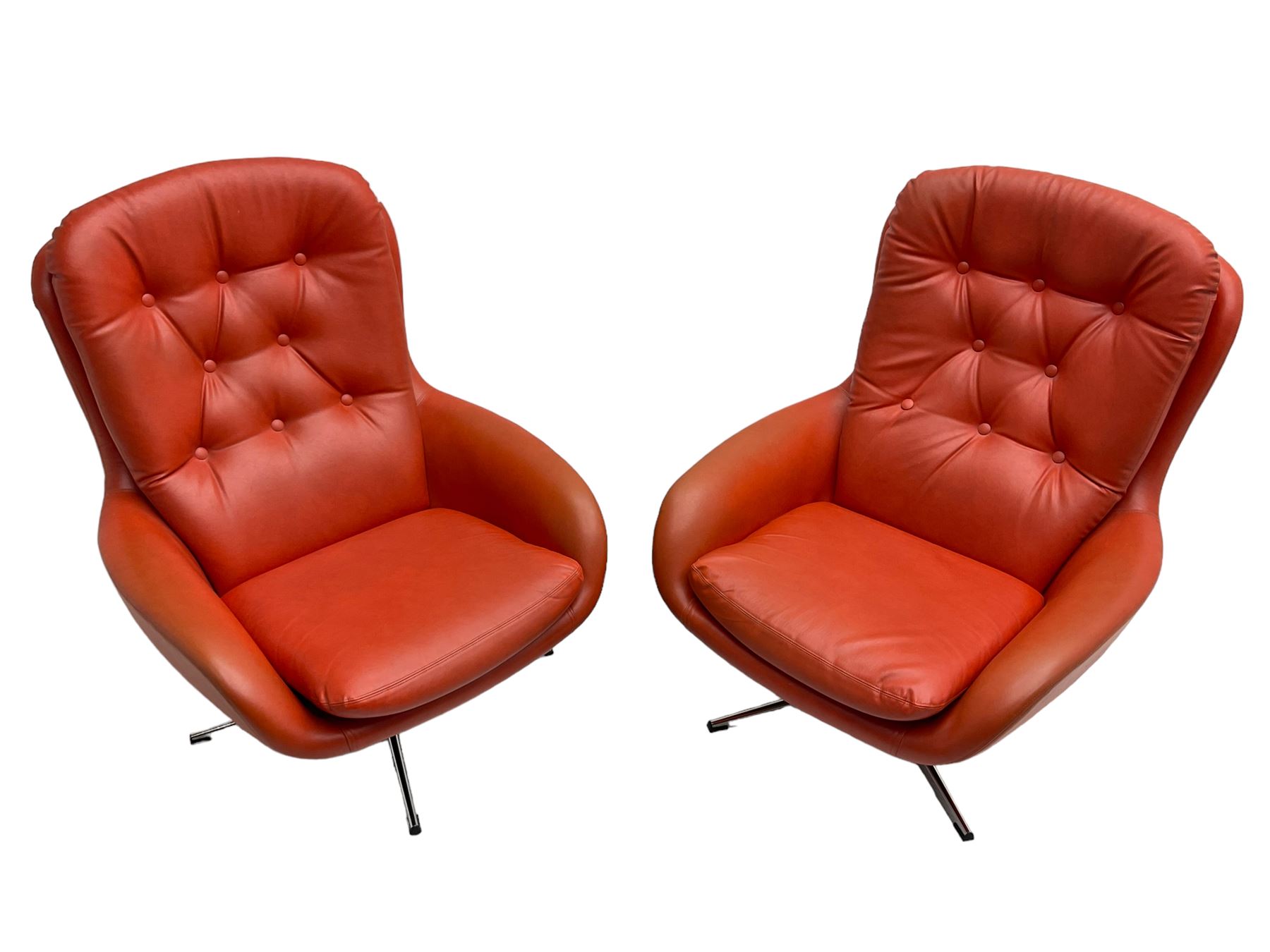 Pair mid-20th century circa.1974 swivel lounge chairs upholstered in buttoned red faux leather, on polished metal base