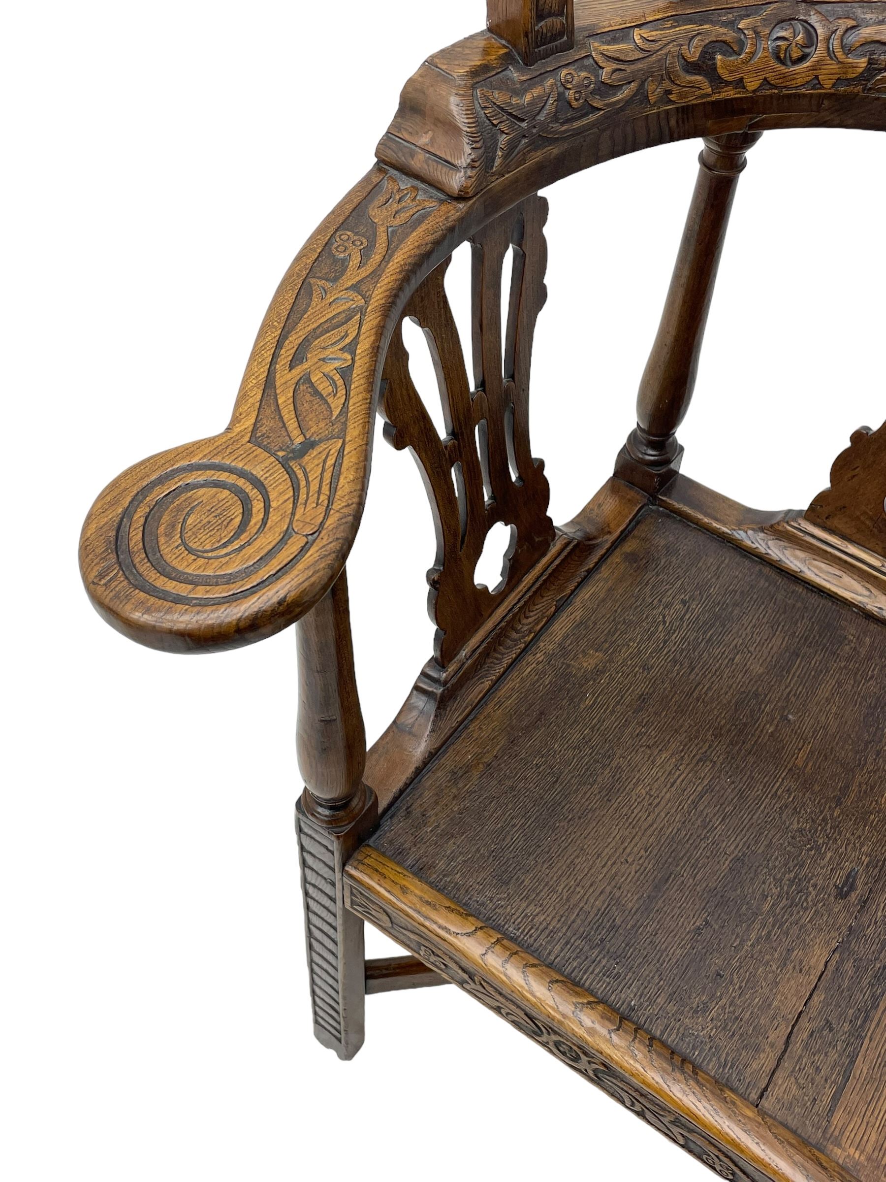 Elm 'Windsor' splat back corner armchair, shaped cresting rail carved with leaves over shaped and pierced splat, the curved arms carved with foliage and scrolled terminals, turned upper supports and a further two splats, panelled seat within foliate carved seat rails, on square rear supports with front shell carved cabriole support, united by plain x-frame stretchers