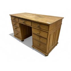 Waxed pine twin pedestal desk, rectangular top over nine drawers, on compressed bun feet 