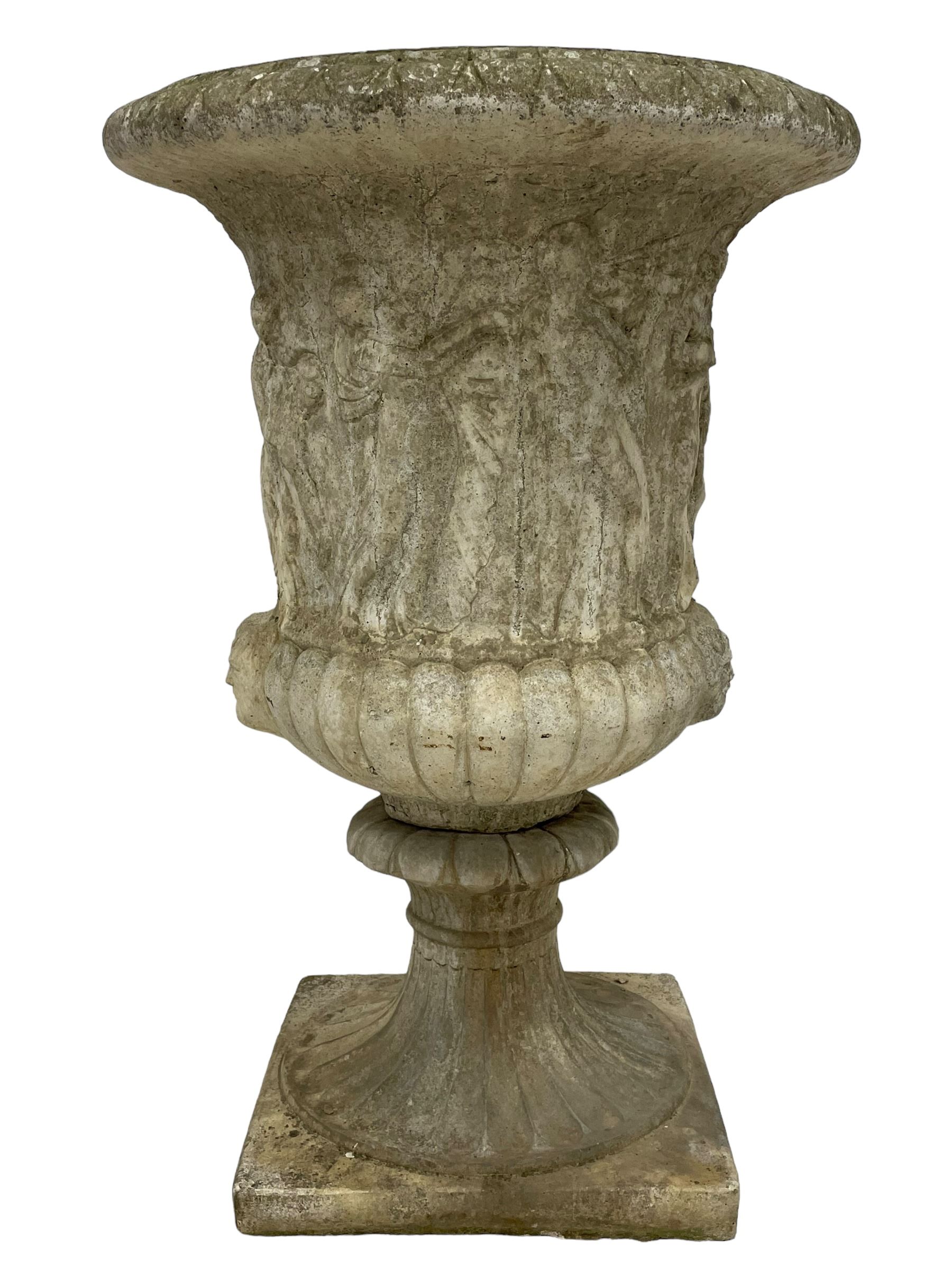 Cast stone Campana shaped urn, decorated with festival scenes over gadrooned underbelly, circular foot on square base