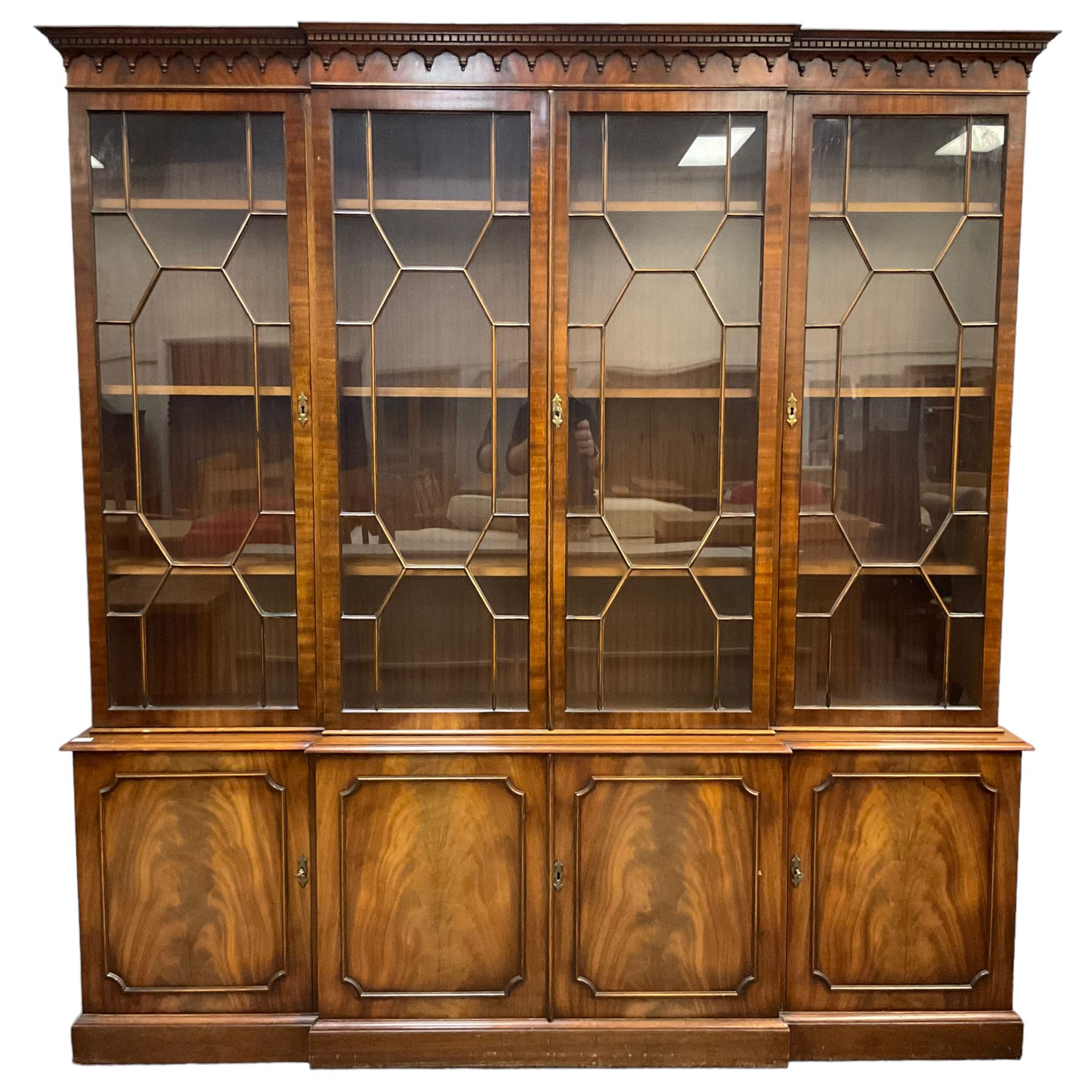 Bevan Funnell - Georgian design mahogany breakfront bookcase, moulded dentil and arcaded frieze over four astragal glazed doors, four cupboards below enclosed by figured doors, on skirted base