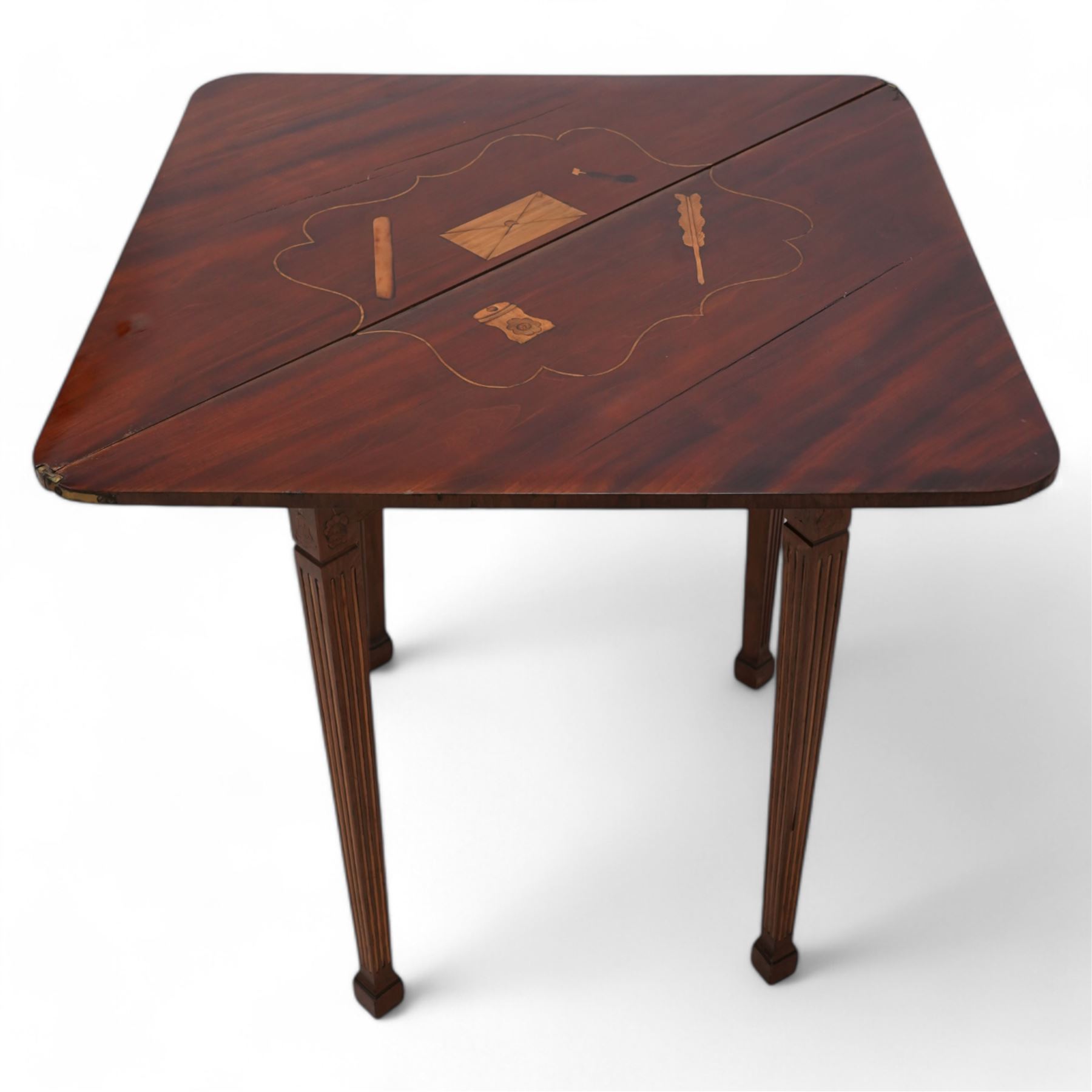 19th century walnut and Dutch marquetry triangular table, the triangular fold-over top reveals a panel of inlaid writing instruments, on square tapering and fluted supports terminating to spade feet 