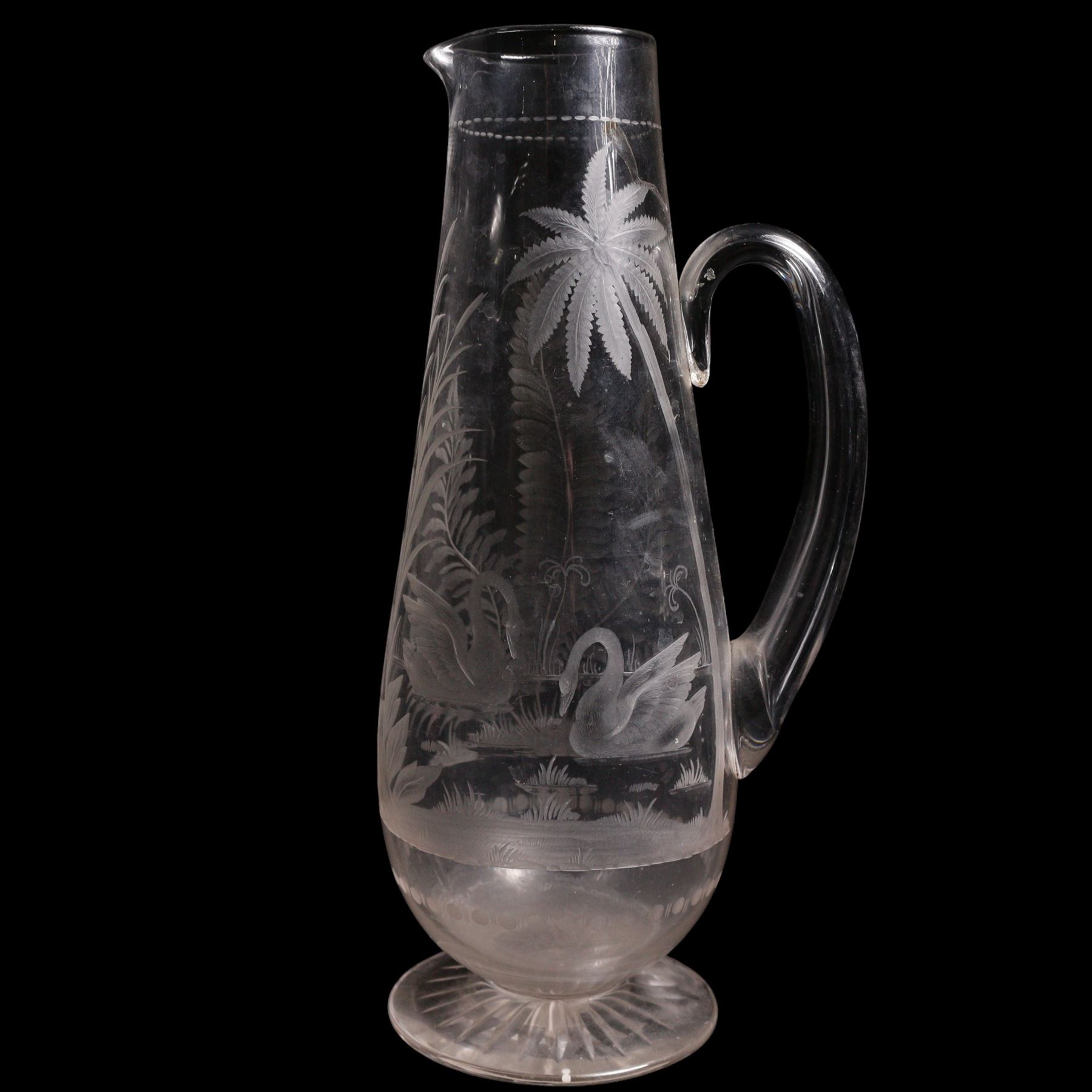 19th/ early 20th century crystal water jug, probably Stourbridge, of baluster form engraved with two Swans on a lake, amongst ferns, reeds and a palm tree, on circular pedestal star engraved foot, H28cm, heavy cut glass jar and cover on pedestal foot, together with a Lalique Samoa frosted glass scent bottle, signed Lalique, France, and labelled 11312 H8cm (3)