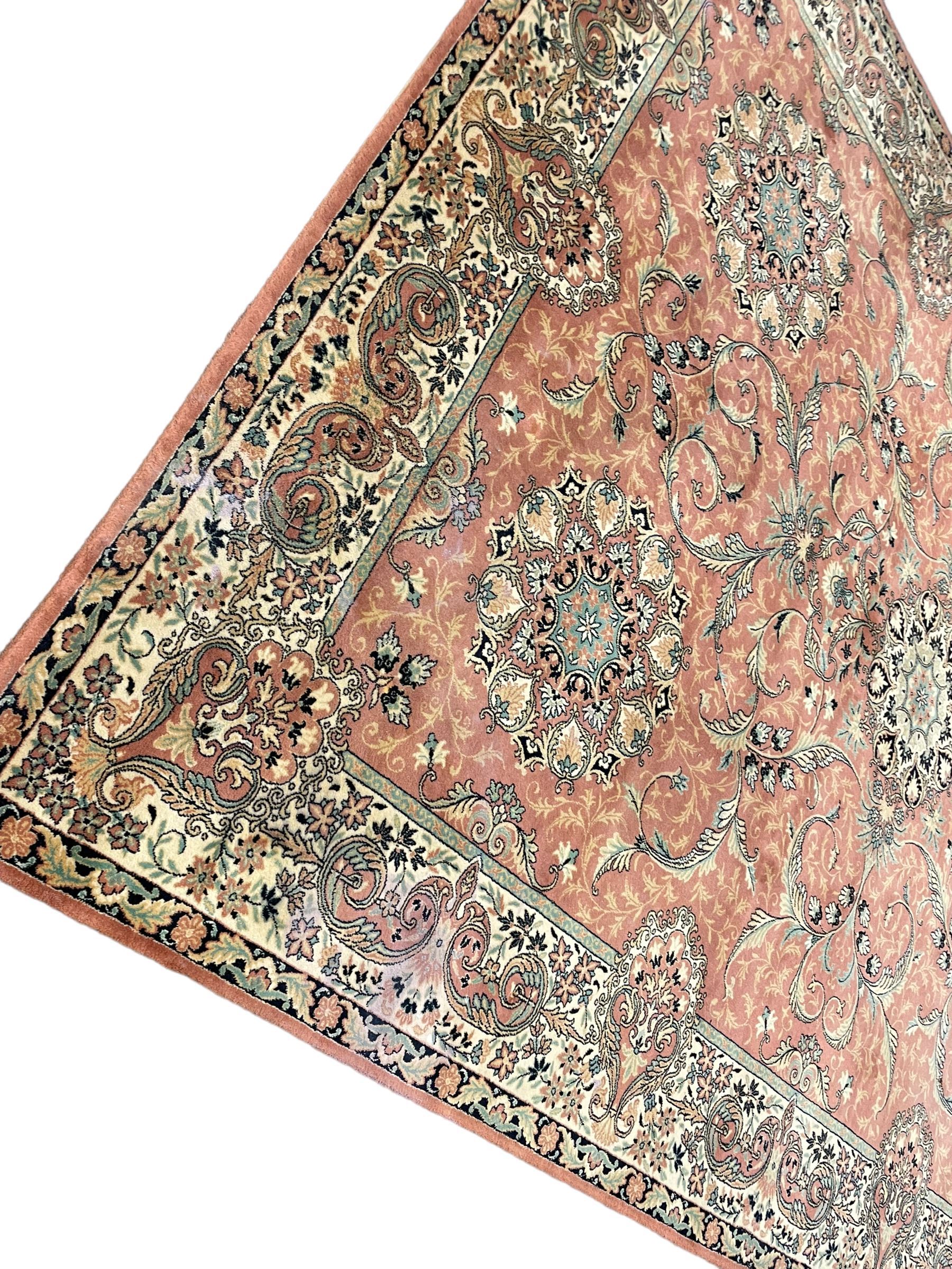 Persian design peach ground carpet, central floral medallion surrounded by scrolling foliage, decorated all over with stylised plant motifs, floral design repeating border