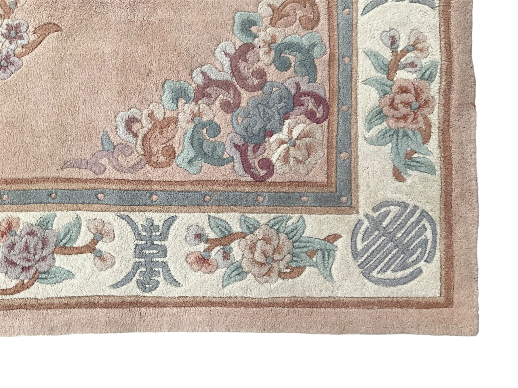 Chinese washed woollen pink ground rug, decorated with floral bouquets and Chinese symbols 