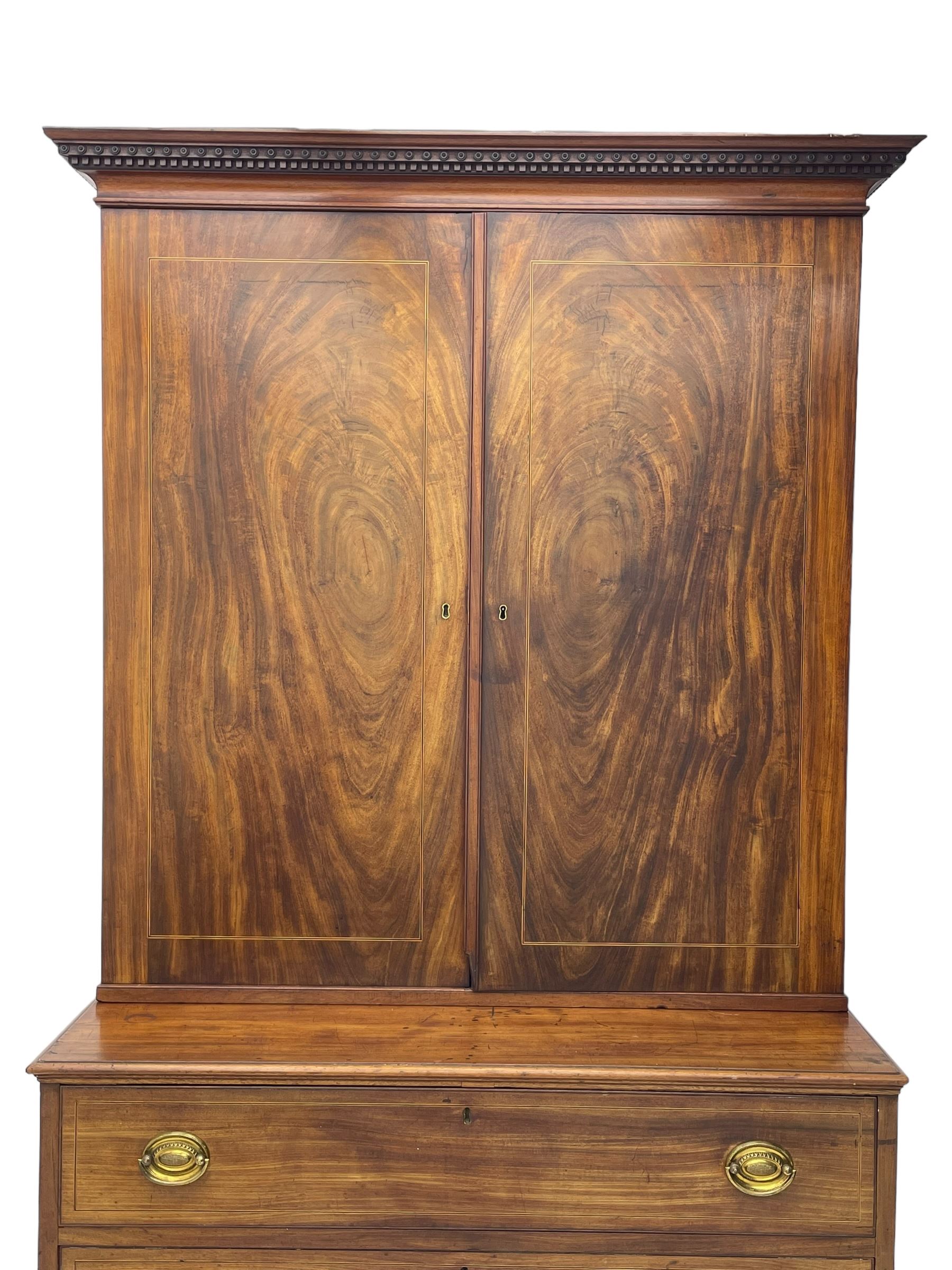 George III figured mahogany secretaire bookcase, projecting moulded dentil cornice decorated with single row of roundels, two figured mahogany doors with boxwood and ebony stringing enclosing three adjustable shelves and three drawers, moulded rectangular top over four long scratch-moulded drawers, the top secretaire drawer with fall front enclosing small drawers, pigeon holes and inset writing surface, shaped apron with bracket feet