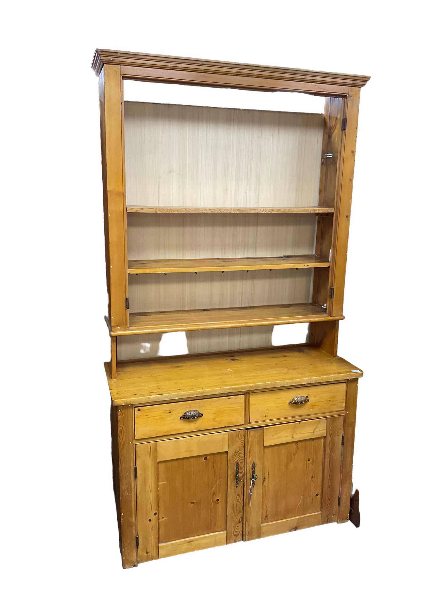 19th century polished pine dresser, the dresser rack fitted with three shelves, the base with two drawers over two panelled cupboards