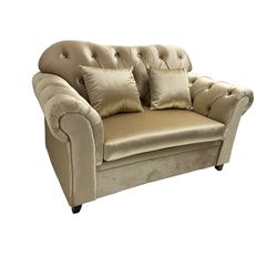 Chesterfield shaped snuggler sofa, upholstered in buttoned champagne fabric, with scatter cushions