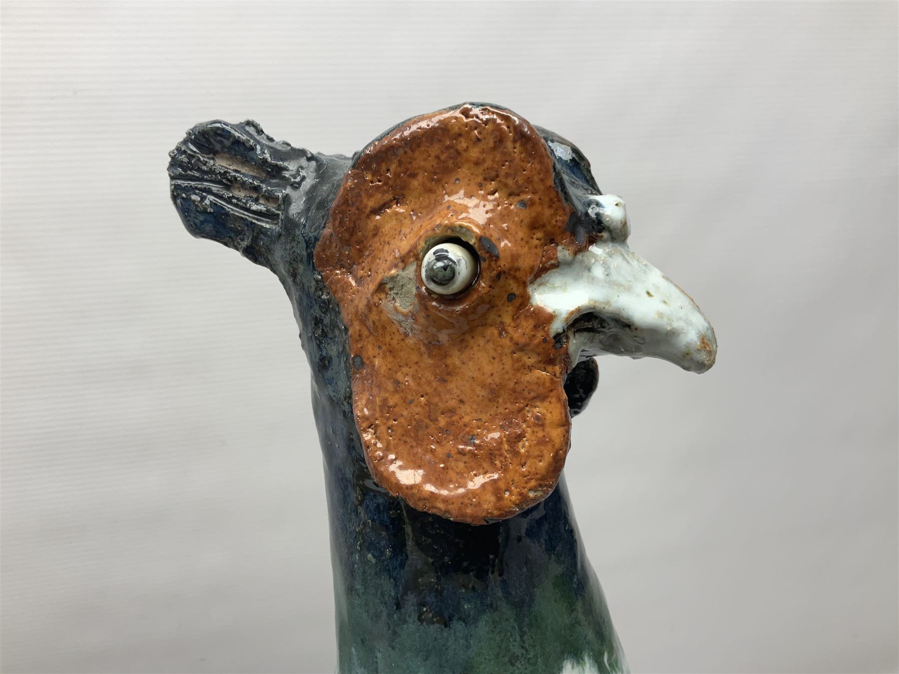 Large stoneware sculpture modeled as a Ring Neck Pheasant, upon a naturalistic base, H55cm, L78cm