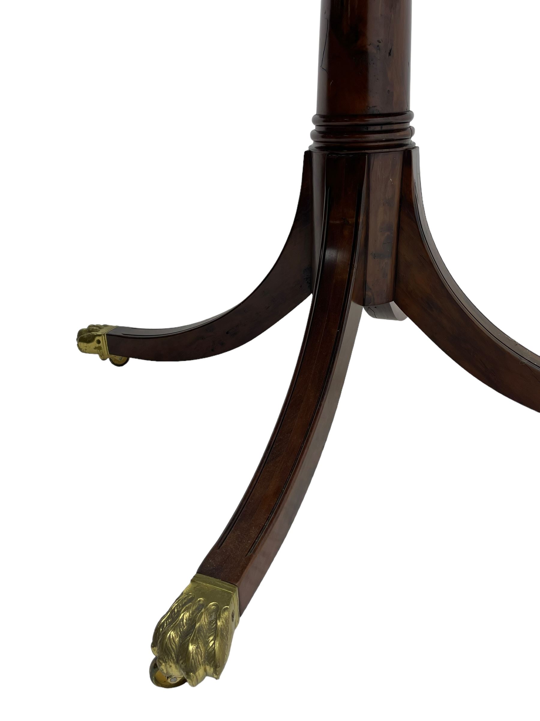 Georgian design inlaid chestnut wood centre table, the circular tilt-top inlaid with satinwood banding, gun barrel turned pedestal on four out-splayed supports, cast brass hairy paw castors, stamped 'P.H.R & Co. Holt, England' 