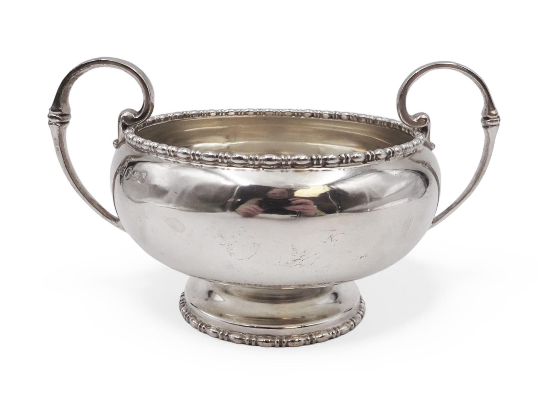 Early 20th century silver twin handled bowl, of plain bellied form with bead and dart rim and two C scroll handles, upon a circular foot, hallmarked Walker & Hall, Sheffield 1919, including handles H9.5cm