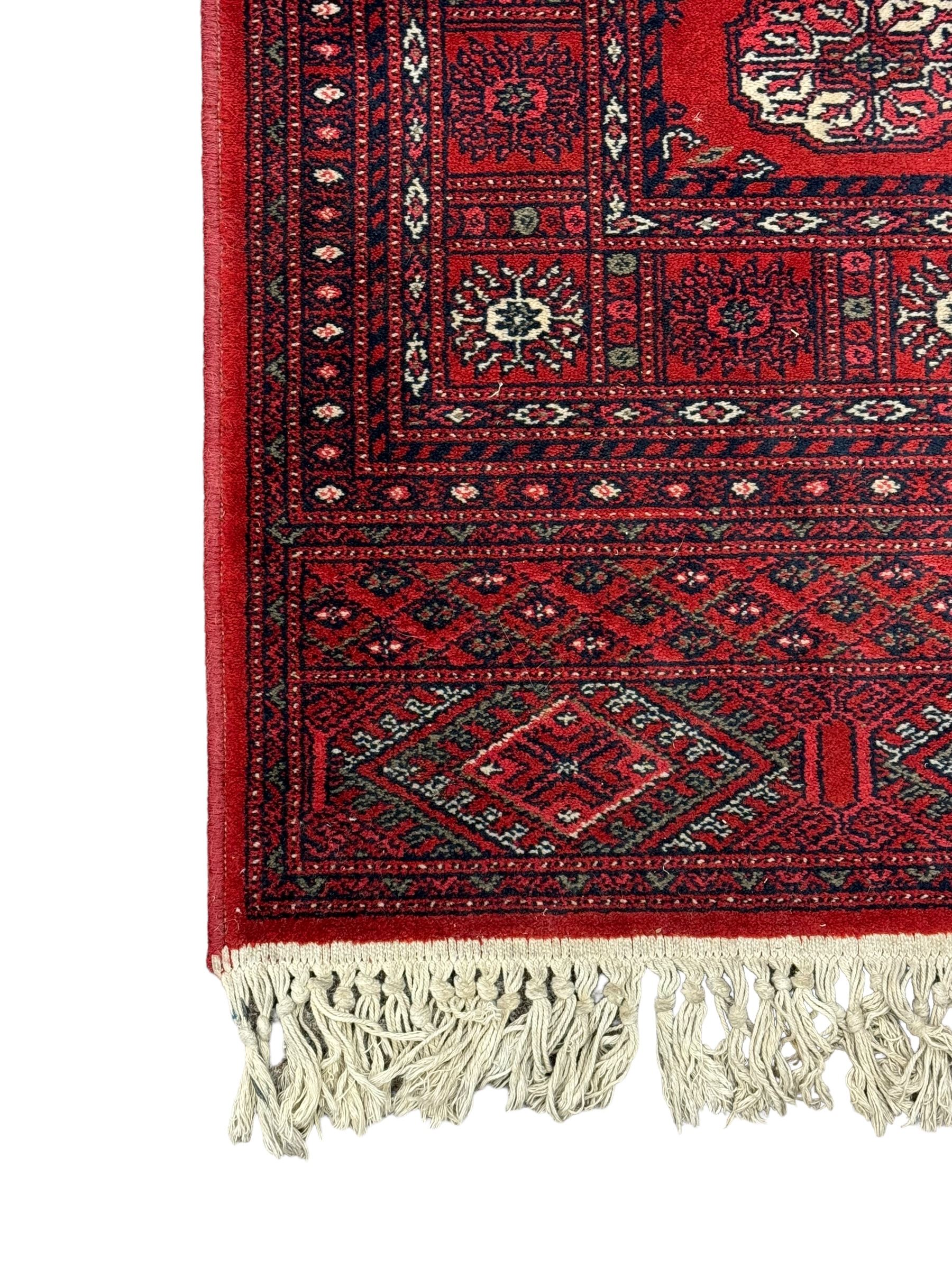 Persian Bokhara crimson ground runner rug, the field with a series of repeating ivory octagonal medallions, main border with repeating flower head pattern and diamonds within multiple guard stripes