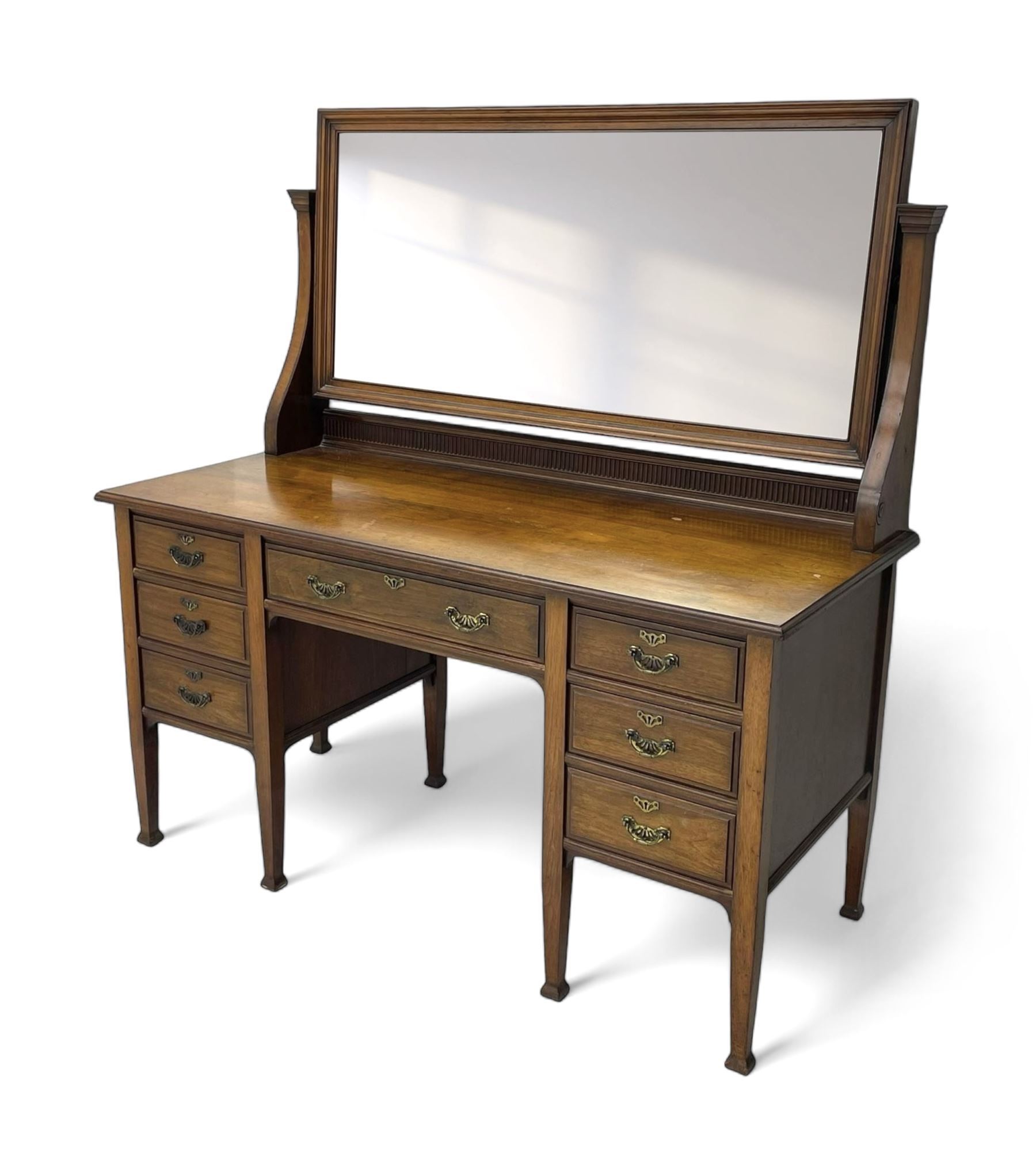 Late 19th century walnut dressing table, wide rectangular bevelled swing mirror in moulded frame, shaped horns carved with scrolls, moulded rectangular top over seven drawers, on square tapering supports with spade feet 