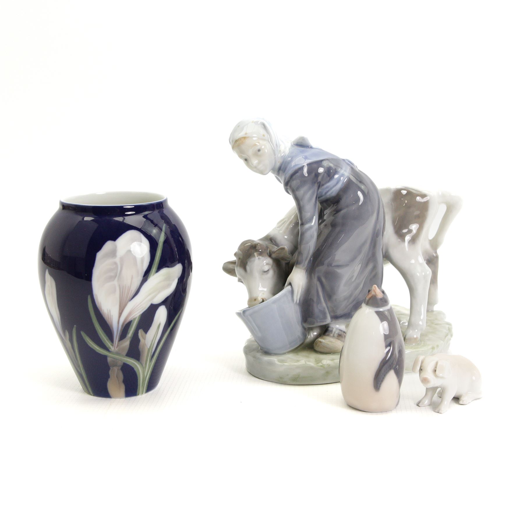 Royal Copenhagen figure of a girl feeding a calf No.799 H16cm, Copenhagen cobalt blue vase decorated with crocus H12cm, Copenhagen penguin No.3003 and a Bing & Grondahl pig