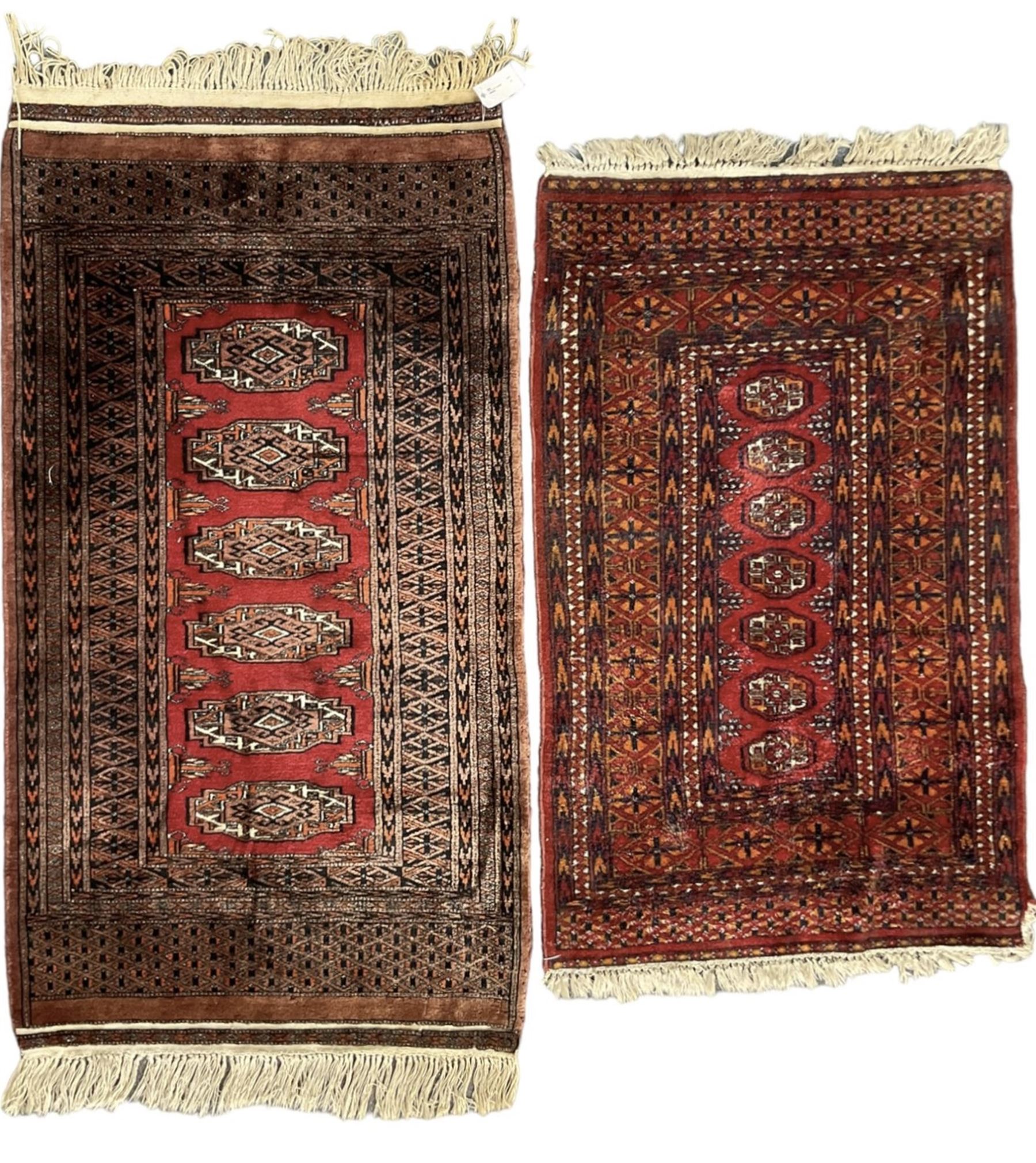 Persian Bokhara dark amber round rug, crimson field with six Gul motifs, surrounded by a guarded border with geometric design (124cm x 70cm); together with another similar in amber and red (101cm x 63cm) (2)