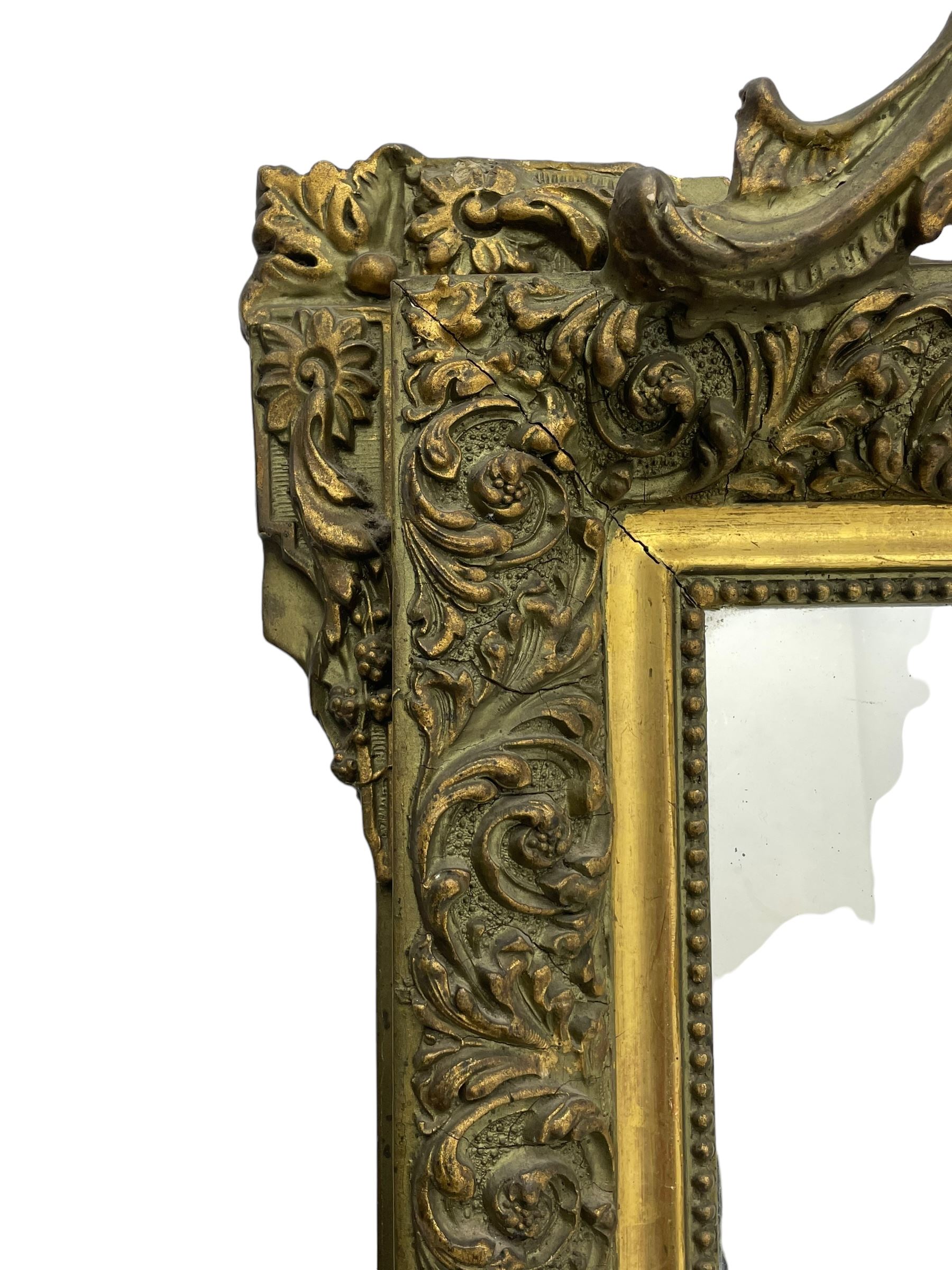 Victorian giltwood and gesso wall mirror, pierced shell cartouche pediment decorated with C-scrolls and curled leaves, moulded frame with curled acanthus leaf decoration and beaded inner slip, the corner brackets decorated with flower heads 