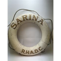 Four mid 20th century yacht lifebuoys, each painted in gold and black lettering 'Sarina R.H.A.D.C', upon a white ground, D68cm