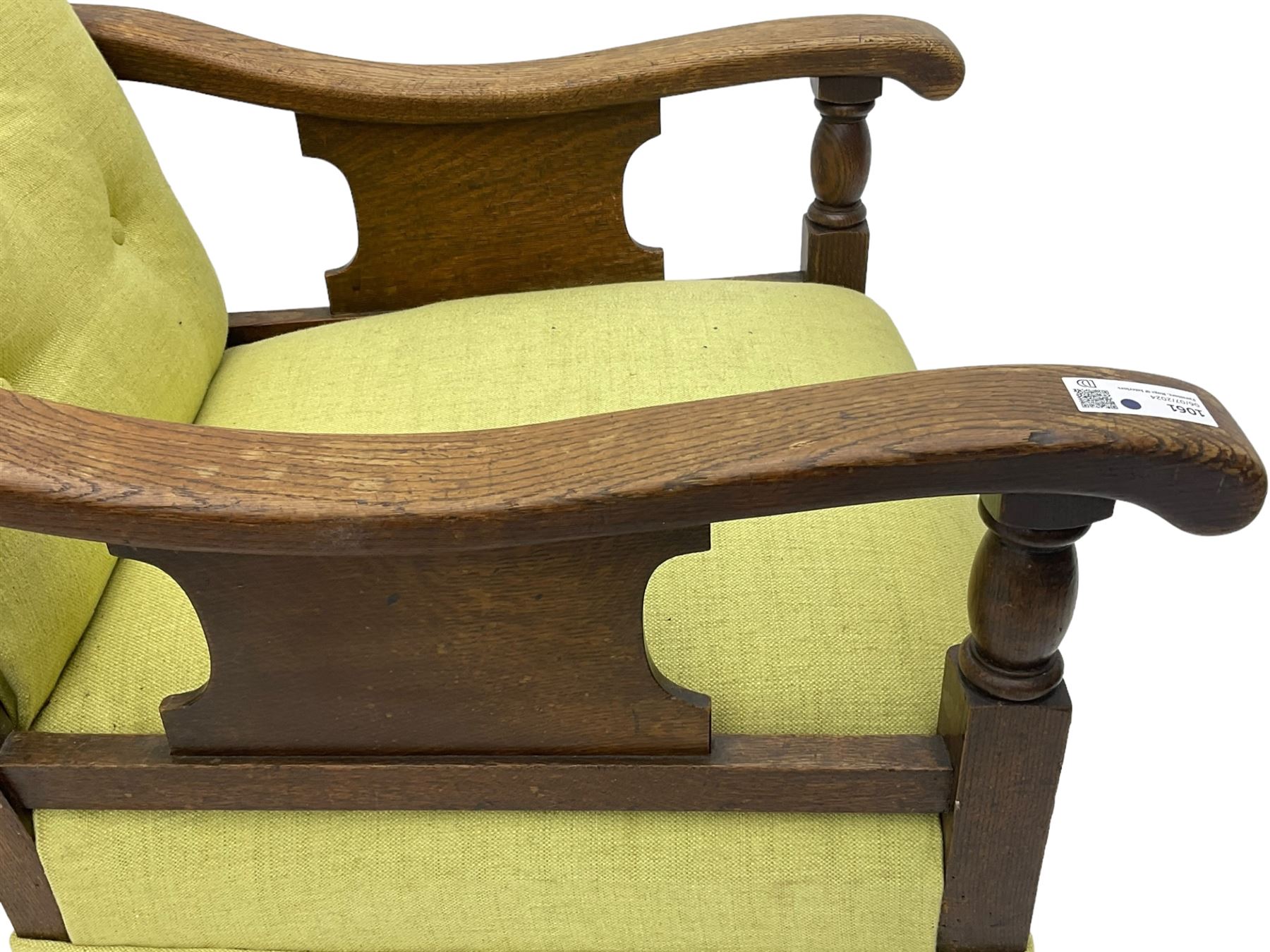 20th century oak framed rocking chair, curved armrests with shaped support panel, upholstered in lime-green fabric with button-tufting on the backrest, concealed springs to facilitate rocking motion underneath, supported by turned front legs with castors