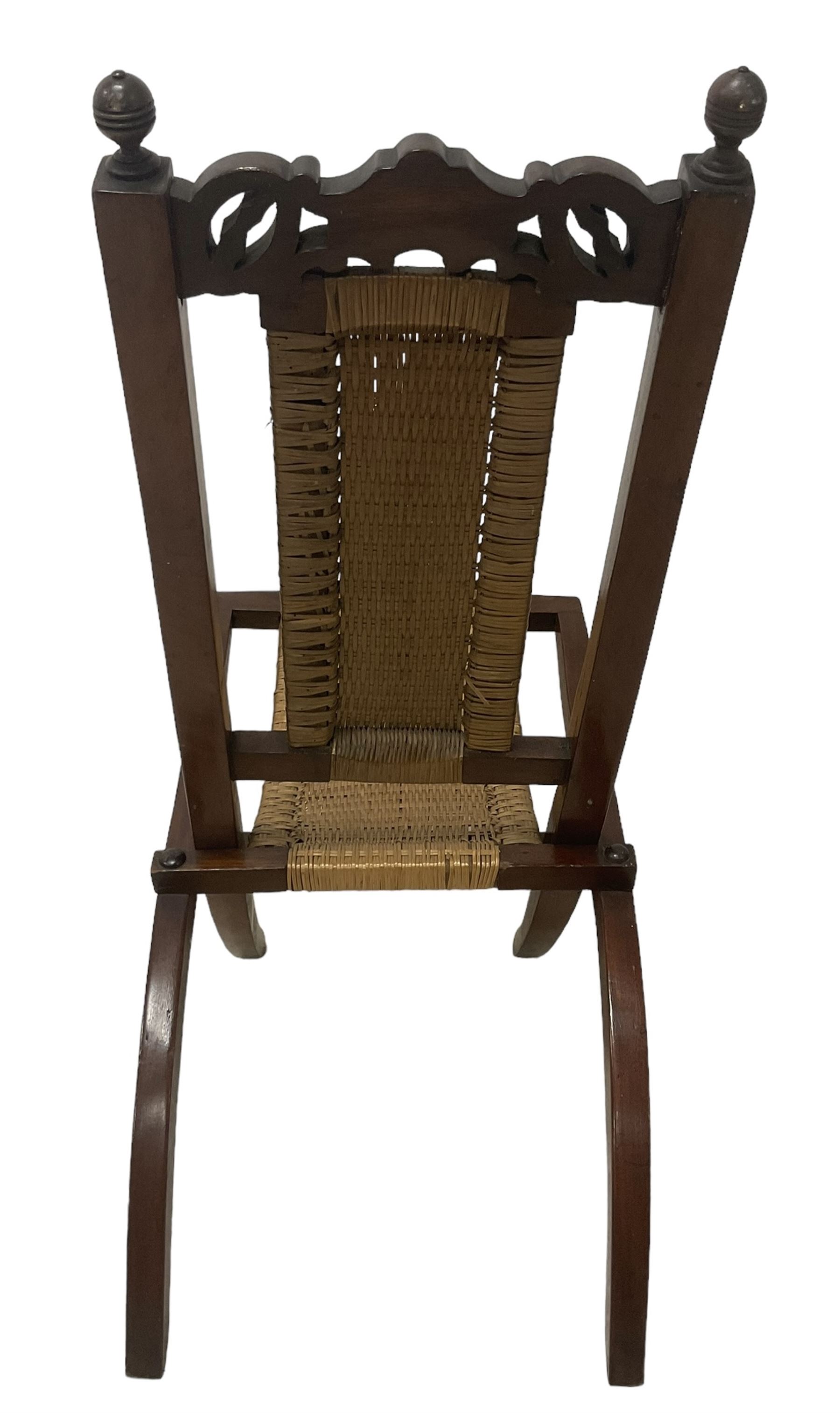 Victorian Aesthetic Movement mahogany framed folding campaign chair, pierced and carved cresting rail with carved and chamfered uprights, rattan back and seat