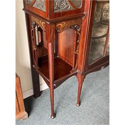 Art Nouveau period inlaid mahogany display cabinet, raised shaped and moulded pediment over projecting moulded cornices, the upper frieze inlaid with trailing branches and tulips, single astragal and bevel glazed door enclosed velvet lined interior fitted with shelves, flanked by curved glass panes decorated with pierced metal foliate spandrels, lower flanking shelves with mirror backs enclosed within shaped and pierced rails inlaid with flower heads, on tapering octagonal supports terminating to compressed pad feet, the lock stamped 'Salmon Bros, London' 