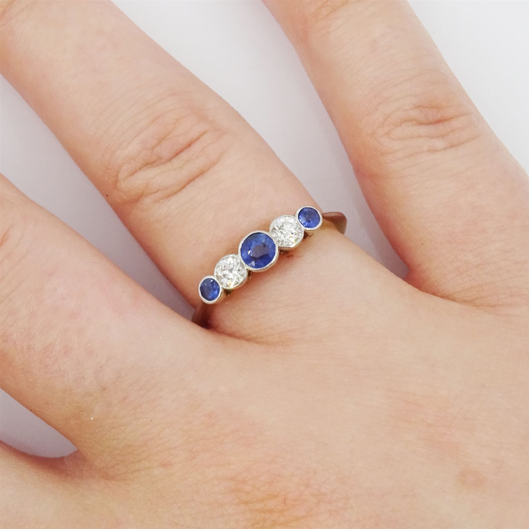 Early 20th century 18ct gold milgrain set five stone round cut sapphire and old cut diamond ring, stamped 18ct, total diamond weight approx 0.20 carat