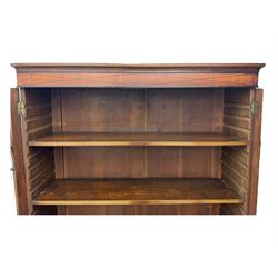 Early 19th century mahogany bureau bookcase, the projecting cornice over two Gothic-style astragal glazed doors enclosing two adjustable shelves, sloped hinged lid enclosing fitted interior and felt inset, four graduating drawers, on bracket feet