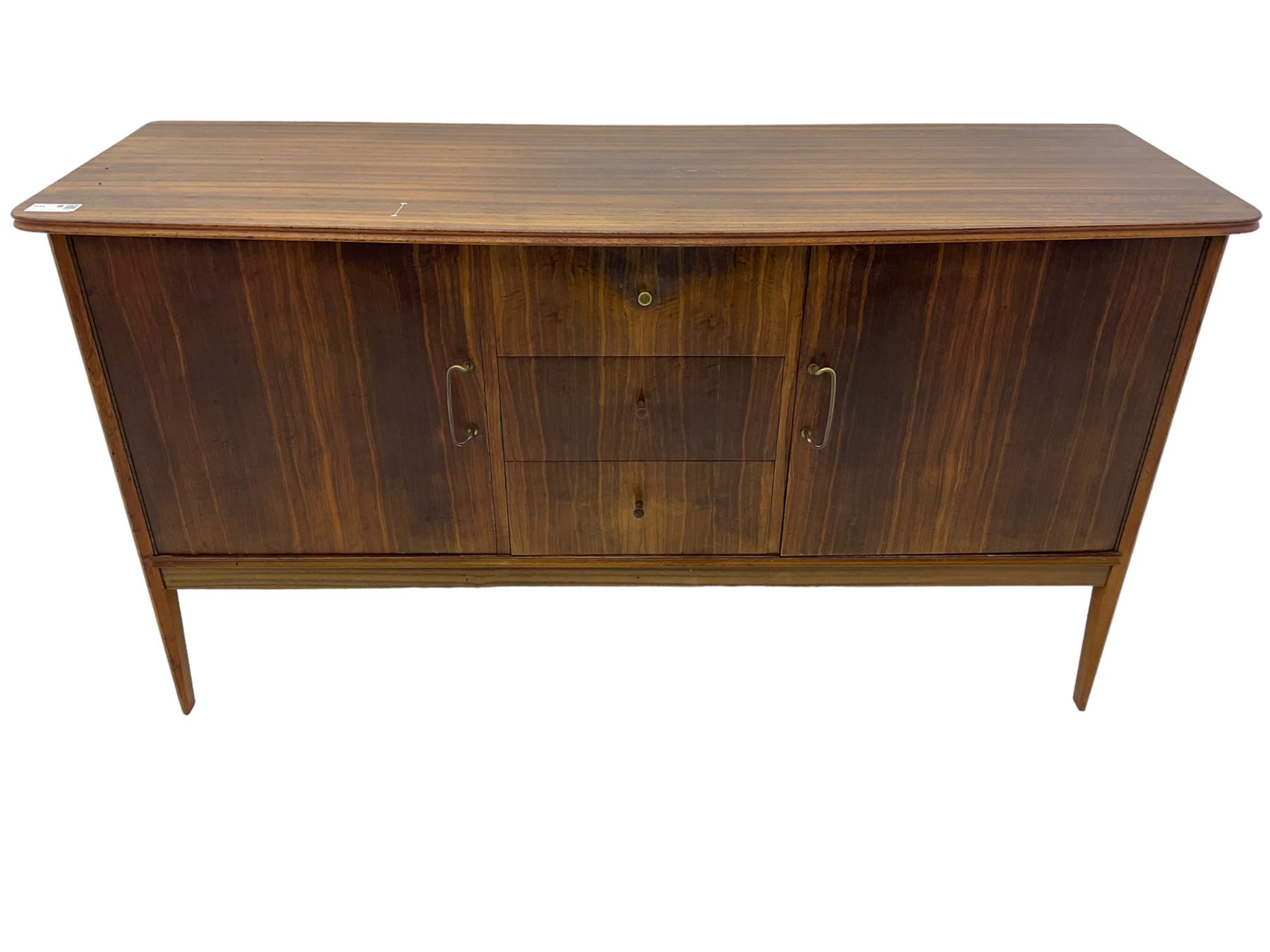 Mid 20th century teak sideboard, rectangular top with rounded corners over three central drawers, flanked by two cupboard doors enclosing shelves, raised on tapered supports