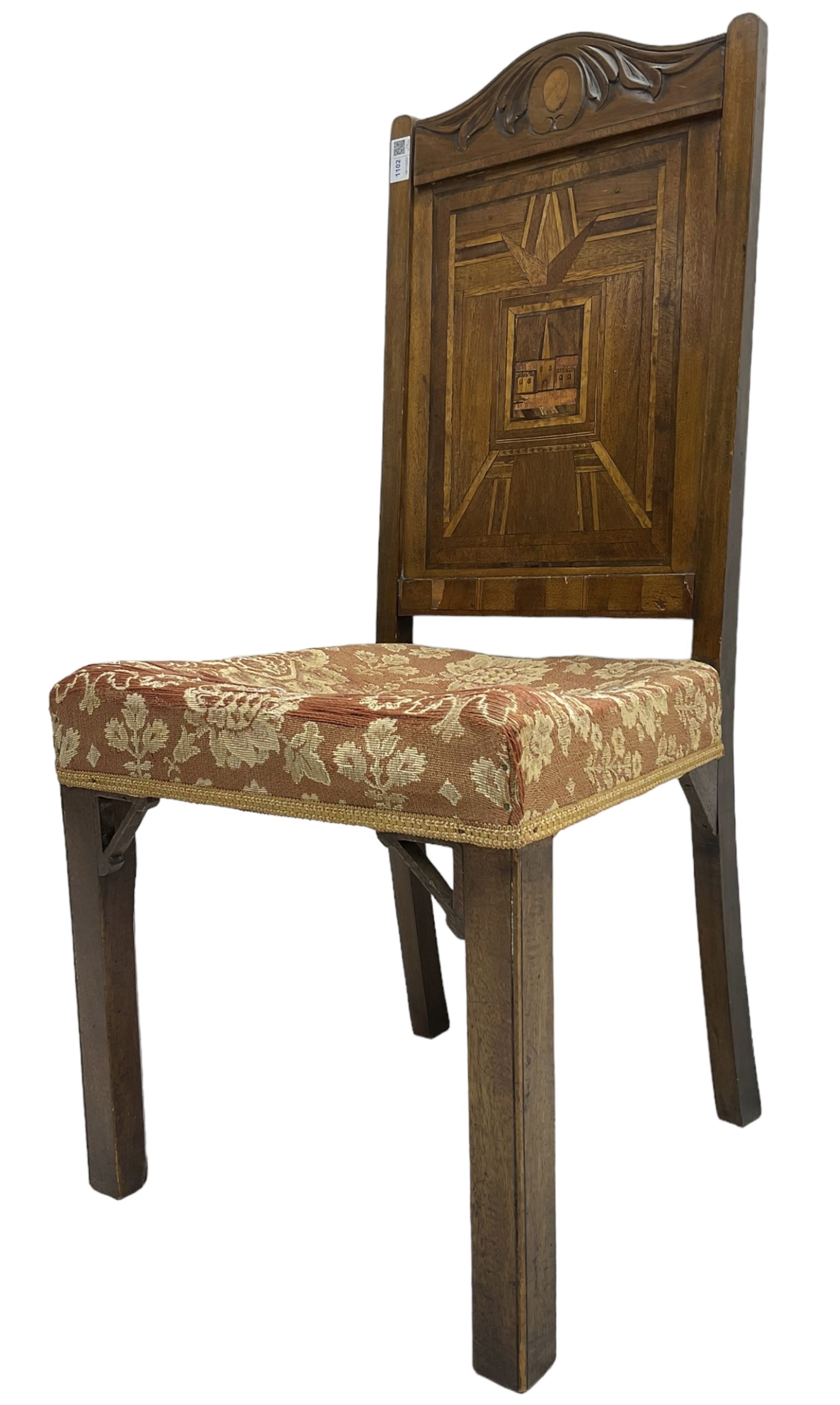 19th century walnut side chair, foliage carved cresting rail over geometric inlaid back with central panel depicting buildings, upholstered seat, on moulded and chamfered square supports