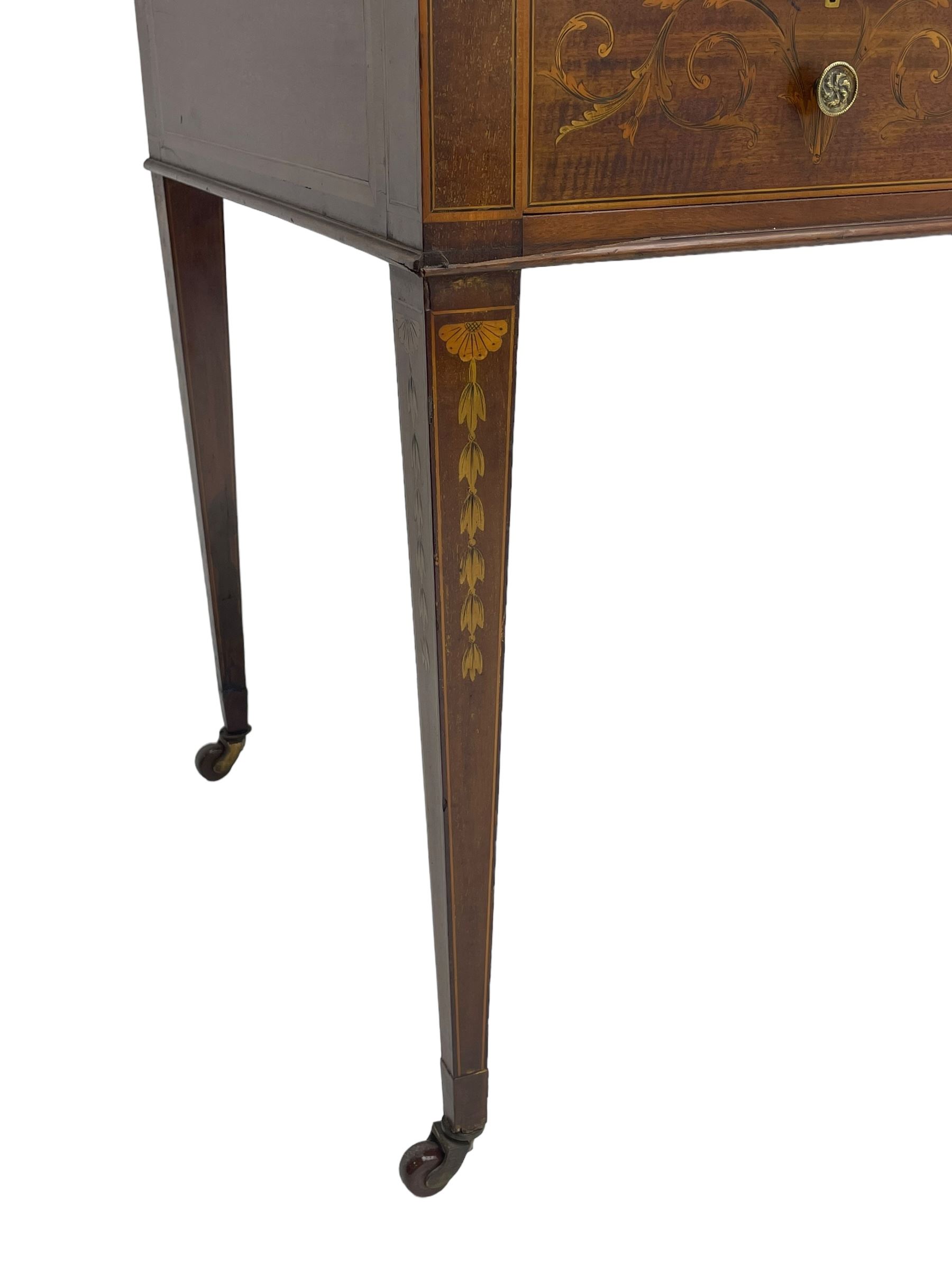 Edwardian inlaid mahogany writing desk, raised galleried back over inlaid central urn with scrolling leafy branches and six small drawers, satinwood banded rectangular moulded top with tooled leather inset, fitted with five drawers, the drawer facias inlaid with scrolling foliage and satinwood banding, square tapering supports inlaid with trailing bell flowers, on brass and ceramic castors 