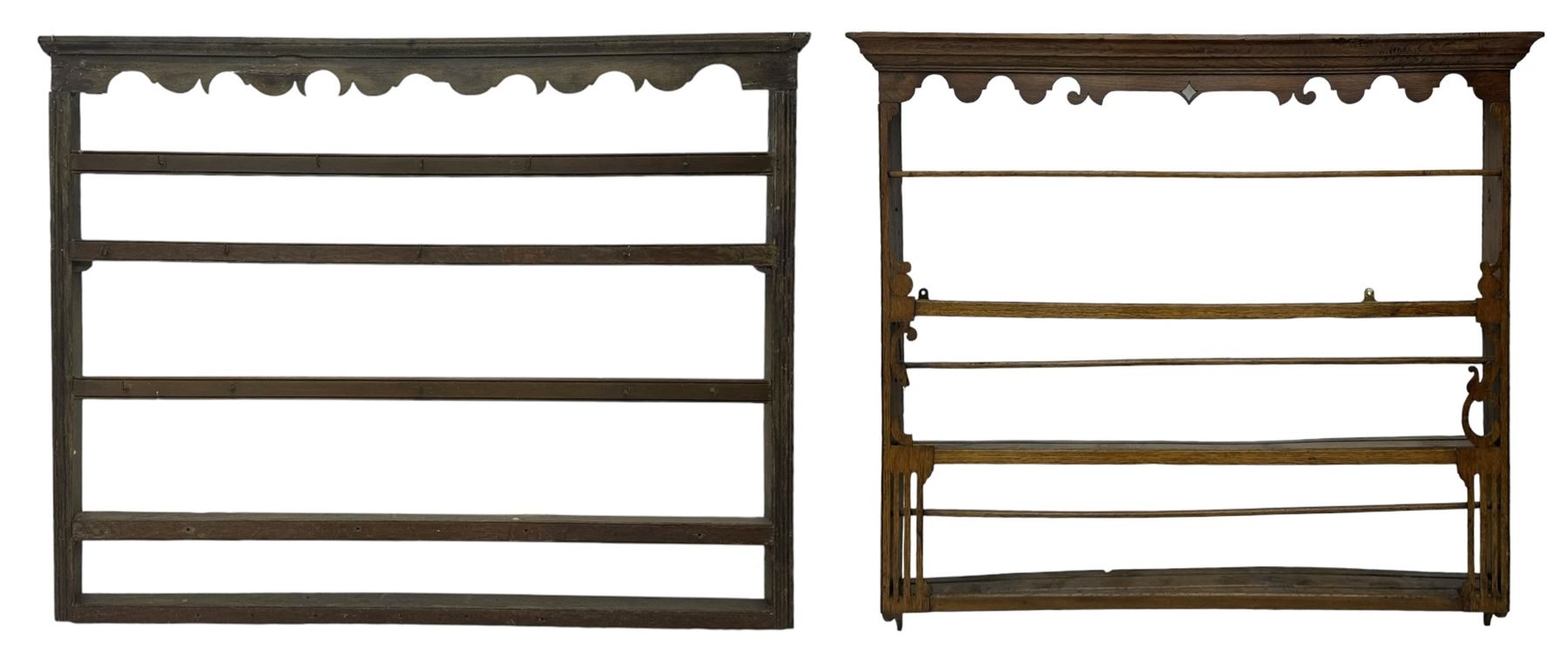 Two Victorian pine plate racks, one with scalloped cornice with central diamond shape and scroll ends over three shelves, the other with scalloped cornice, three shelves and fifteen hooks (2)