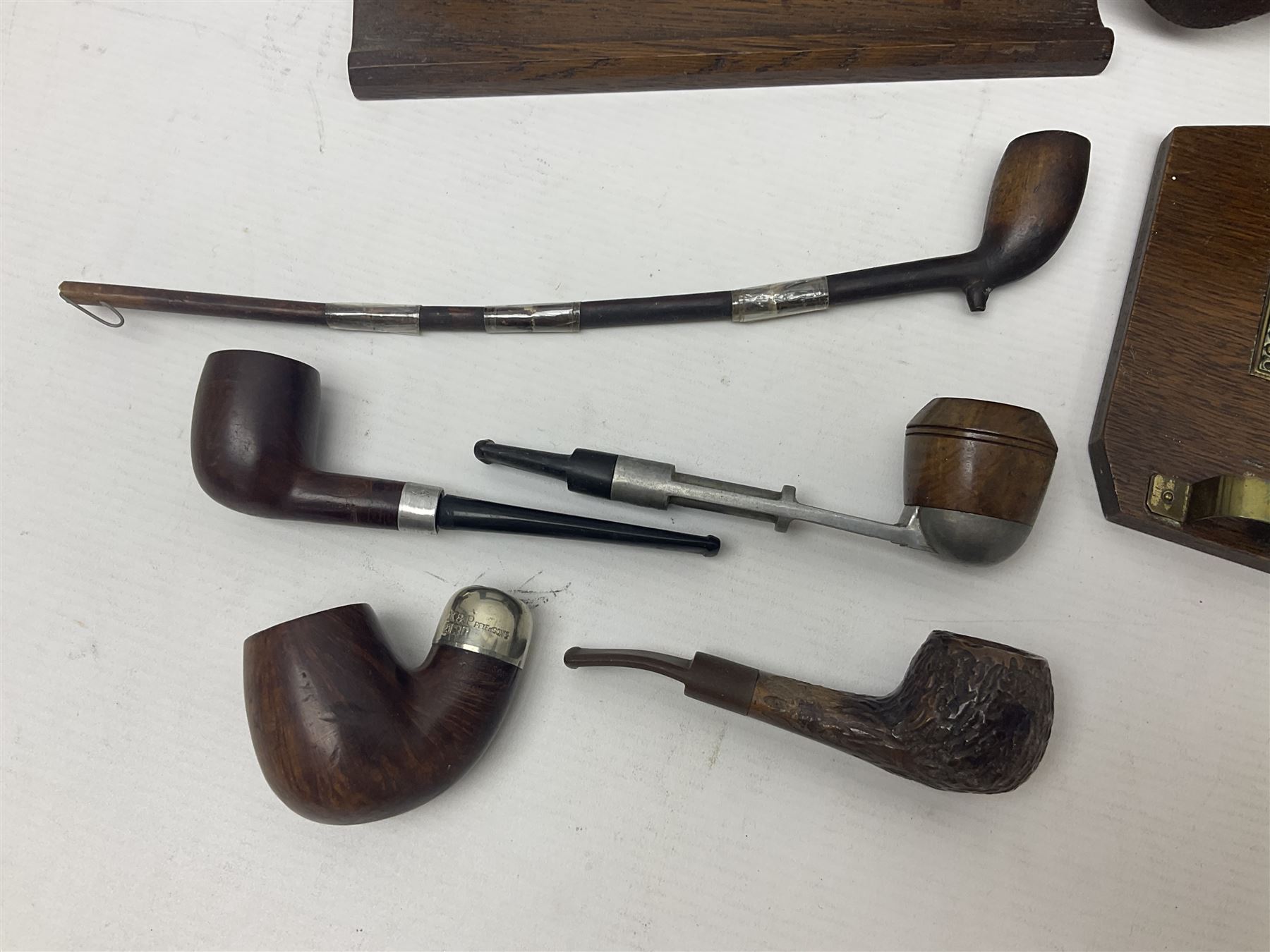 Collection of smoking pipes including Meerschaum pipe, carved as a female head, Briars and clay examples, etc and four pipe racks/stands