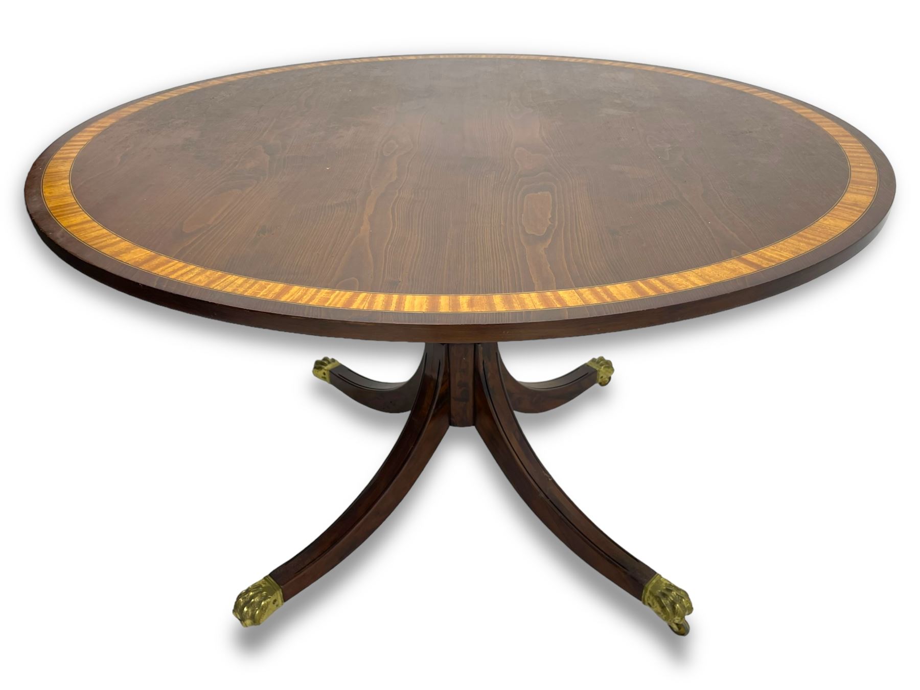 Georgian design inlaid chestnut wood centre table, the circular tilt-top inlaid with satinwood banding, gun barrel turned pedestal on four out-splayed supports, cast brass hairy paw castors, stamped 'P.H.R & Co. Holt, England' 