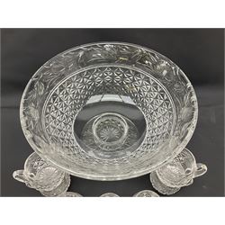 Large Stuart crystal pedestal punch bowl, of circular form, the rim with engraved floral decoration, upon spreading circular foot with radial cut decoration, with seven matching Stuart crystal drinking glasses, each with a C handle, each acid signed beneath, bowl H20cm