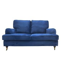 Howard design - two-seat sofa upholstered in blue fabric, traditional shape with rolled arms, on walnut finish turned feet with brushed metal cups and castors