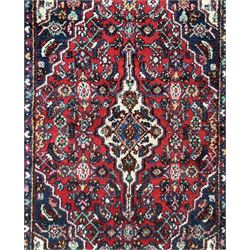 Persian Herati crimson ground rug, central ivory pole medallion surrounded by Herati motifs, with contrasting indigo spandrels, multi-band border with interlaced flowerheads