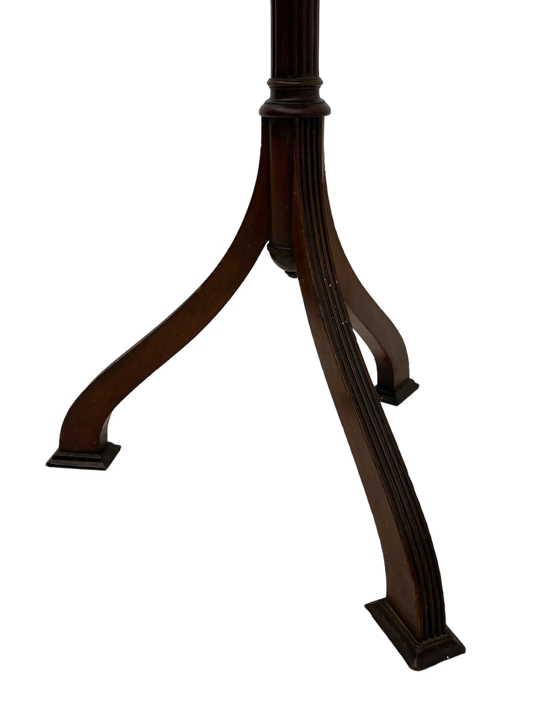 Early 20th century mahogany wine table, figured circular top with reeded edge, on turned and reed moulded stem, three reeded tapered supports on rectangular moulded pad feet 