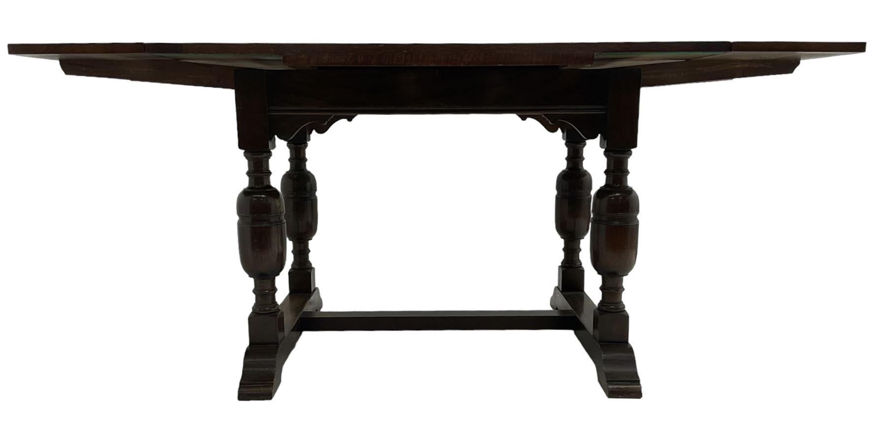 Mid-20th century medium oak dining table, rectangular draw-leaf extending top, quadruple turned pillar supports on sledge feet joined by stretcher