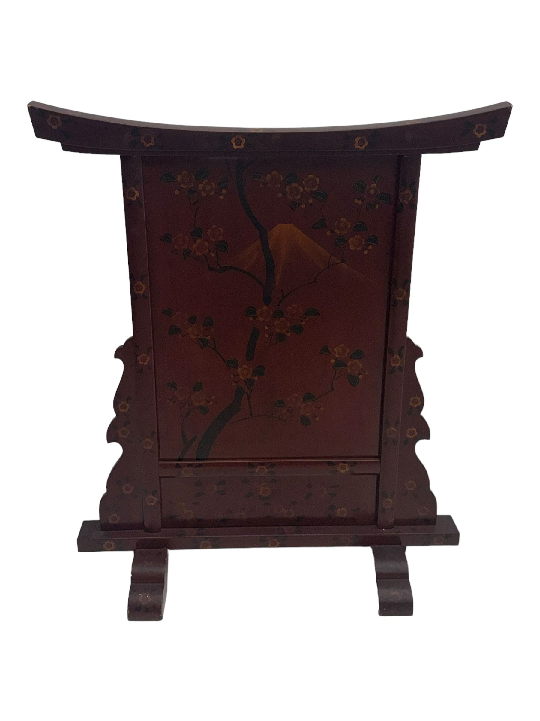 20th century Japanese lacquered table screen, top rail with slight curve and floral painted design, central panel depicting a river scene with Mount Fuji in the background, flanked by shaped supports on rectangular base