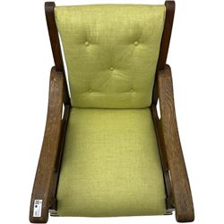 20th century oak framed rocking chair, curved armrests with shaped support panel, upholstered in lime-green fabric with button-tufting on the backrest, concealed springs to facilitate rocking motion underneath, supported by turned front legs with castors